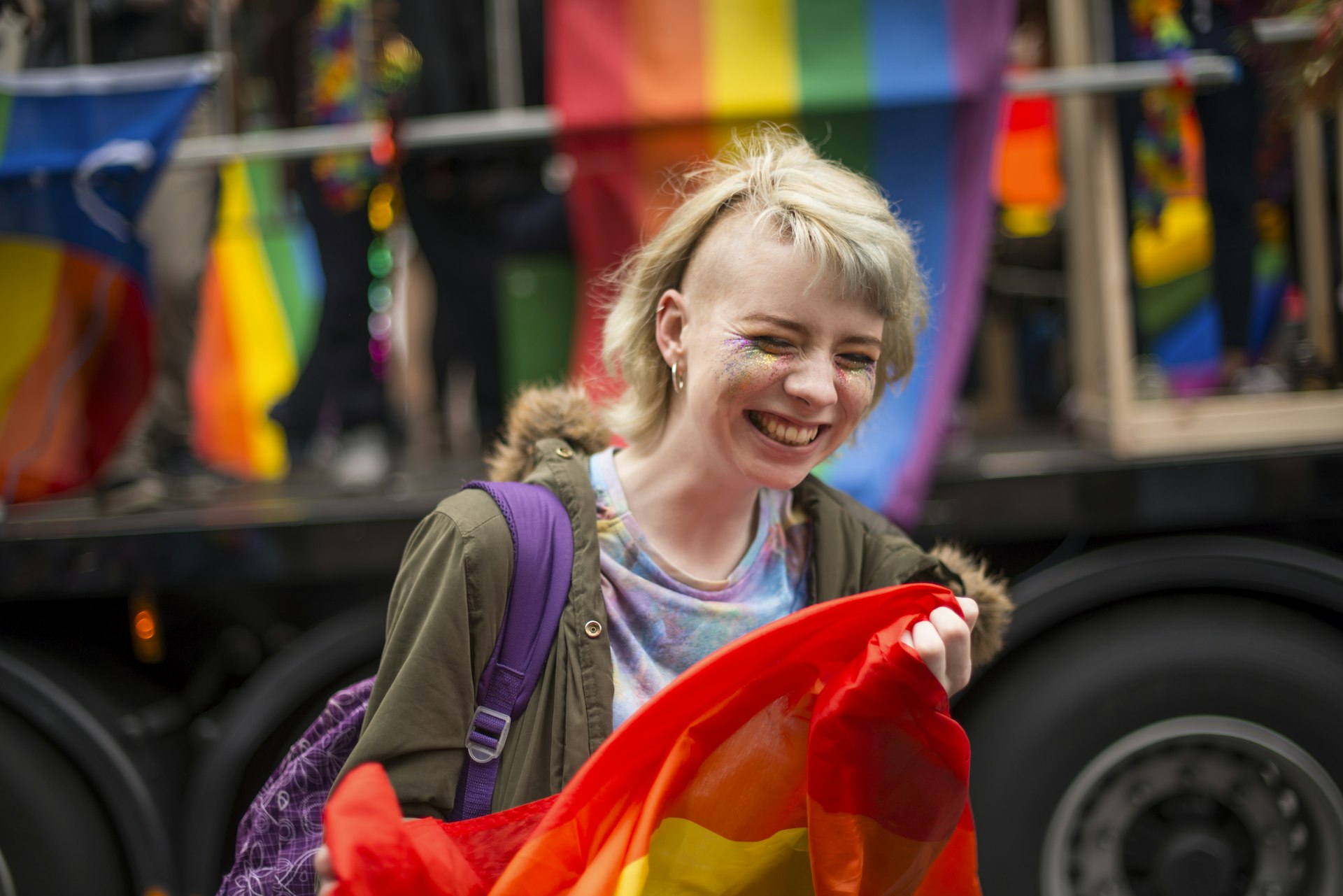 A woman holds a rainbow flag and smiles at the Pride parade, Dublin, Ireland