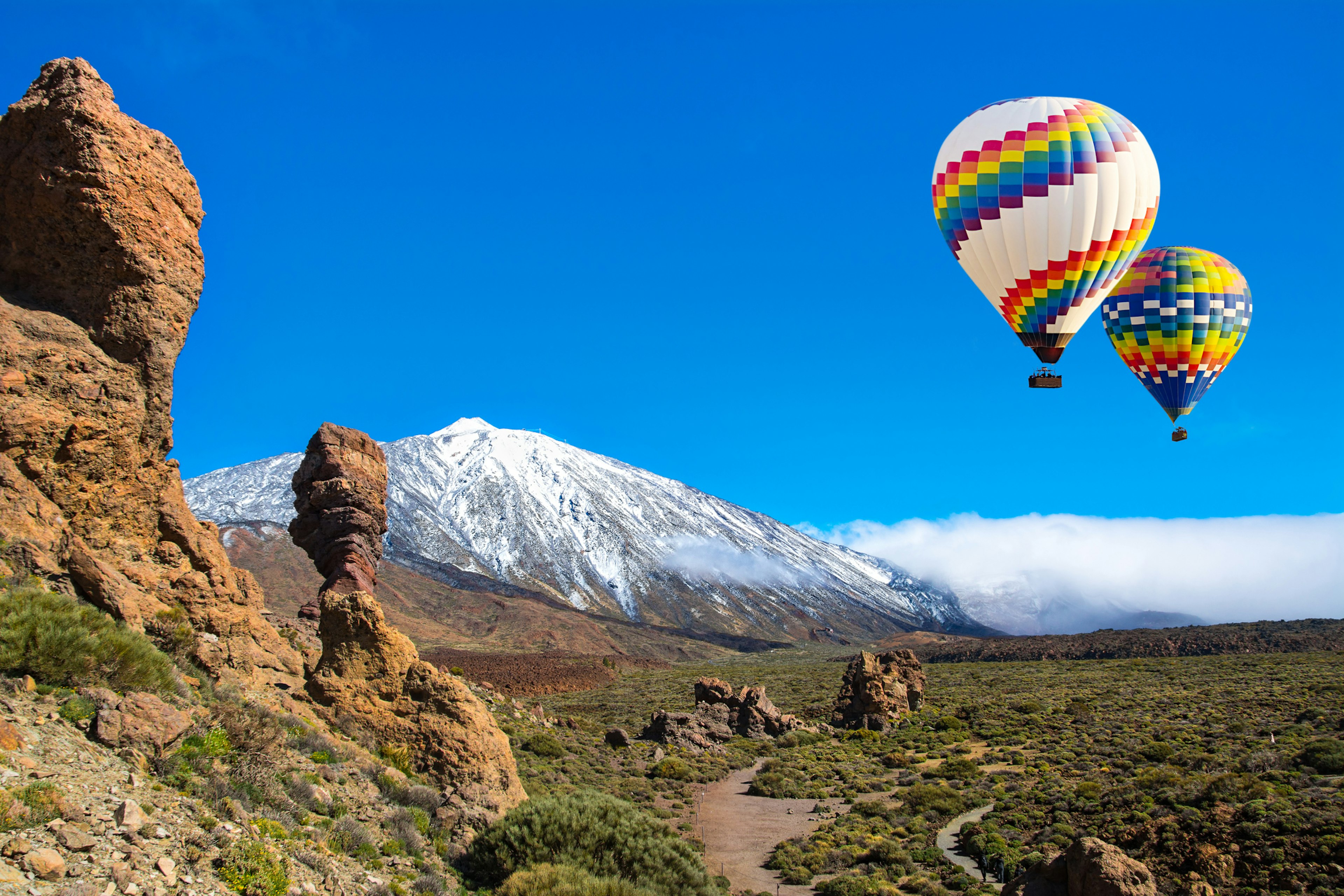 View of Roque Cinchado, a unique rock formation with famous volcano Teide in the background in Teide National Park, Tenerife.