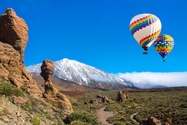 View of Roque Cinchado, a unique rock formation with famous volcano Teide in the background in Teide National Park, Tenerife.
