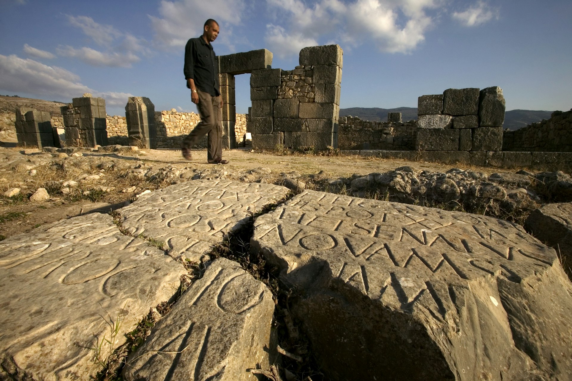 Man walks through the remains of the Roman city of Volubilis