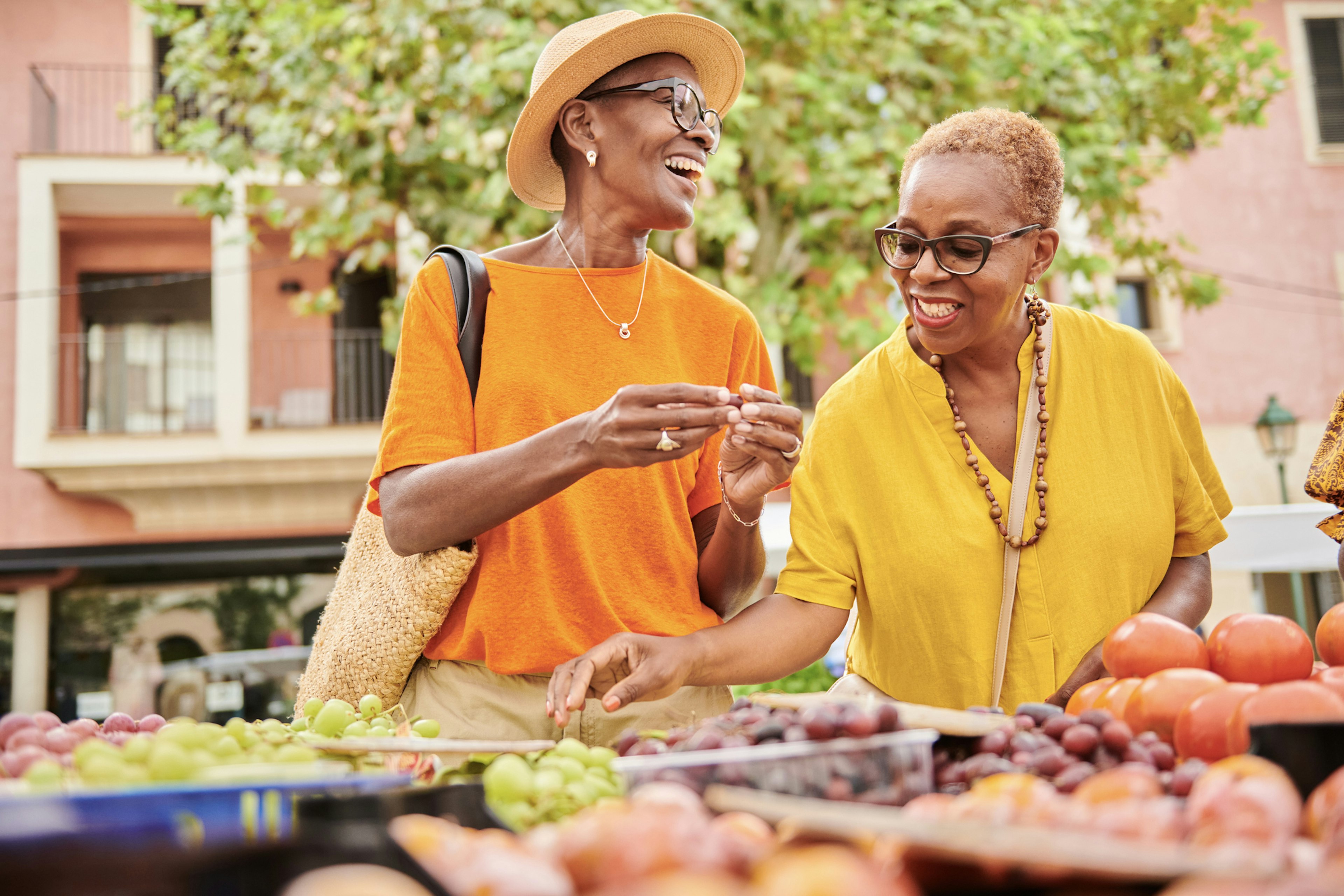 Two women exploring an outdoor food market in traditional old town in Majorca Spain