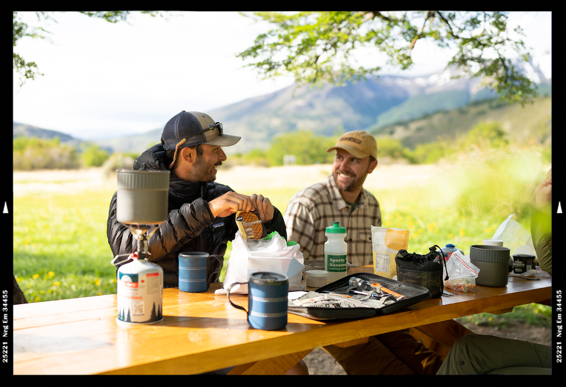 Two men enjoying coffee at campsite before hiking Torres del Paine