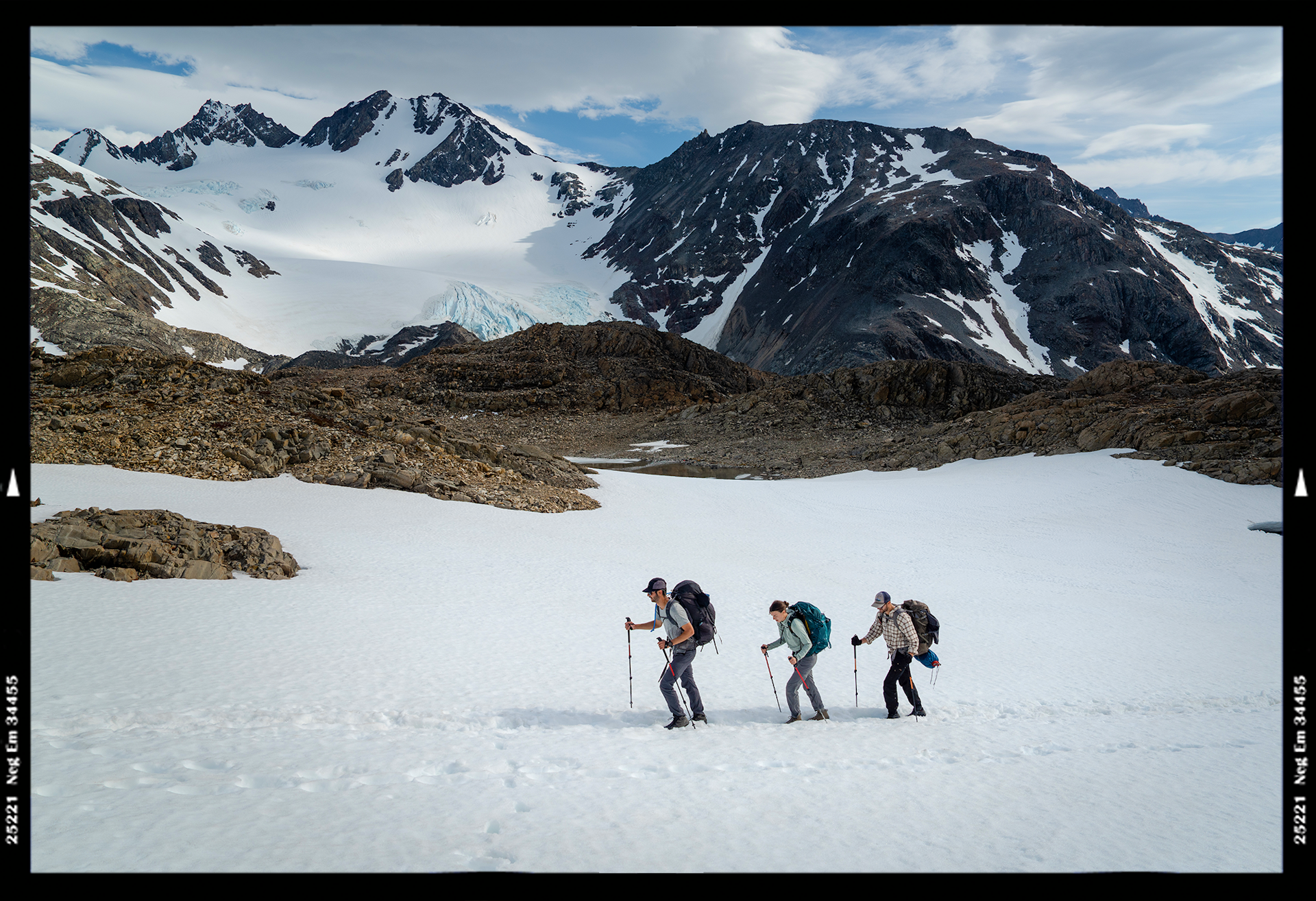 Hikers crossing the snow with hiking poles in Patagonia