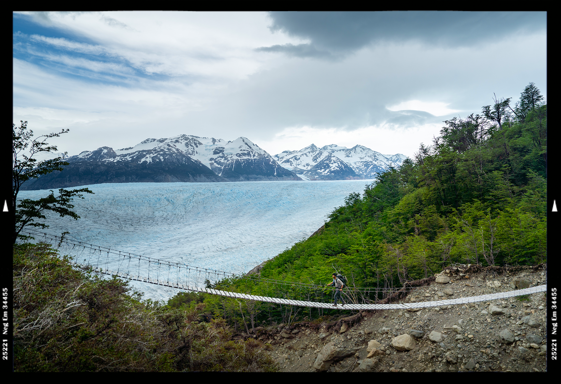 Hikers crossing a suspension bridge near Glacier Valley in Patagonia