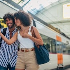 Man and woman, heterosexual couple going traveling with train together, standing on train station, using smart phone.
1170669413
Train station couple