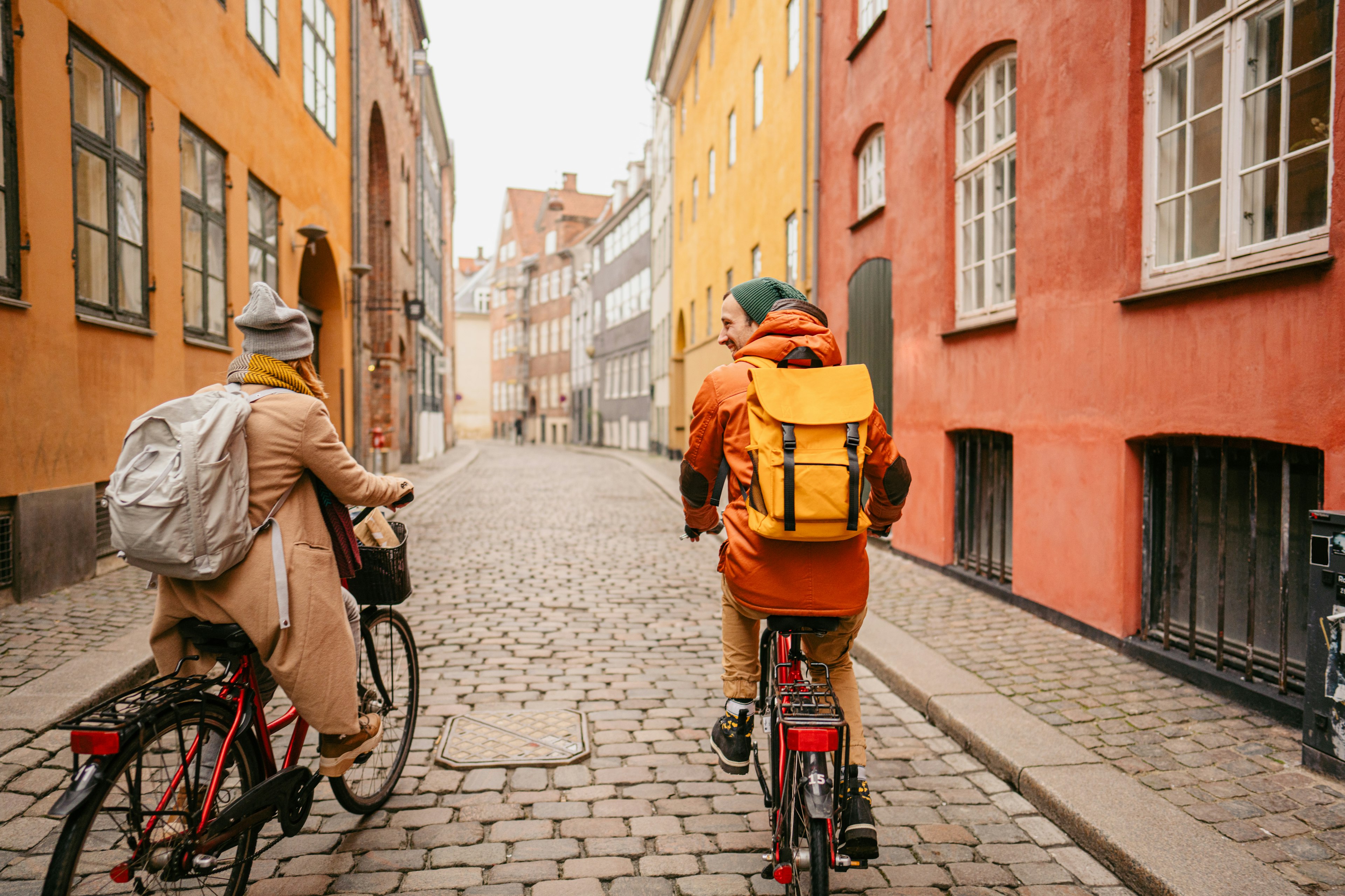 Photo of a young couple riding bicycles and enjoying the lovely winter morning in the city.