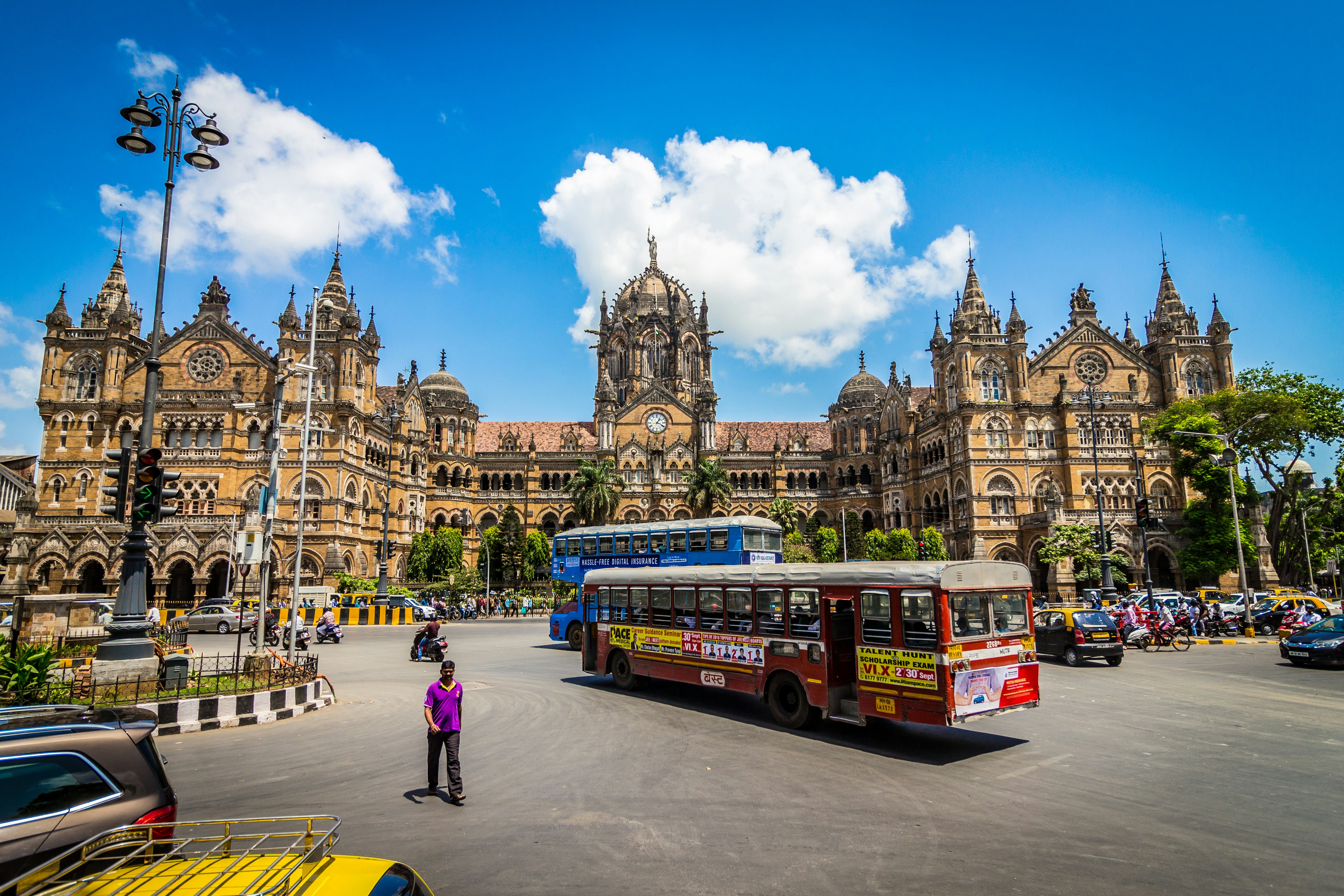 Buses and people in front of Chhatrapati Shivaji Maharaj Terminus in Mumbai, India.