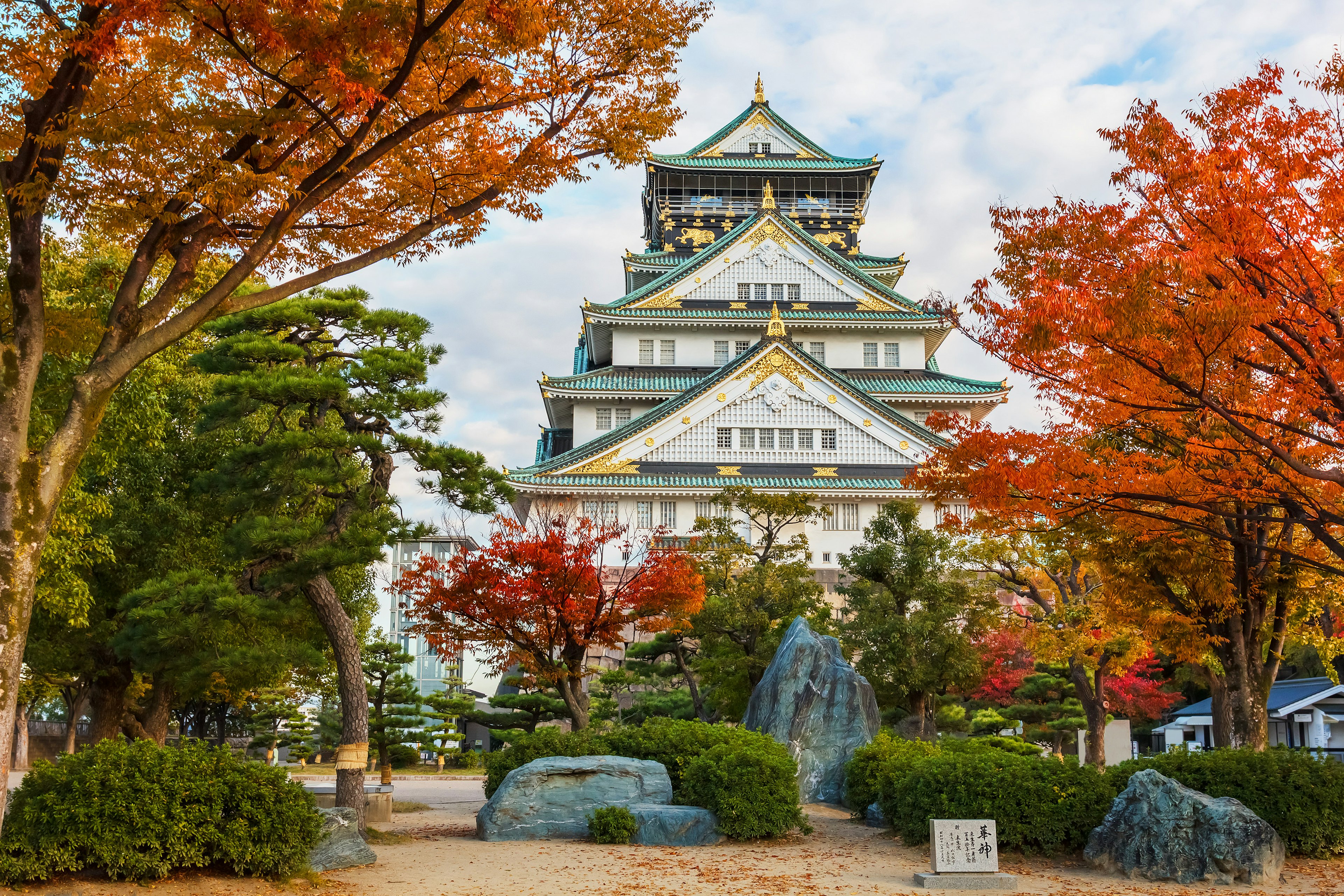 A multi-tiered castle surrounded by autumn leaves