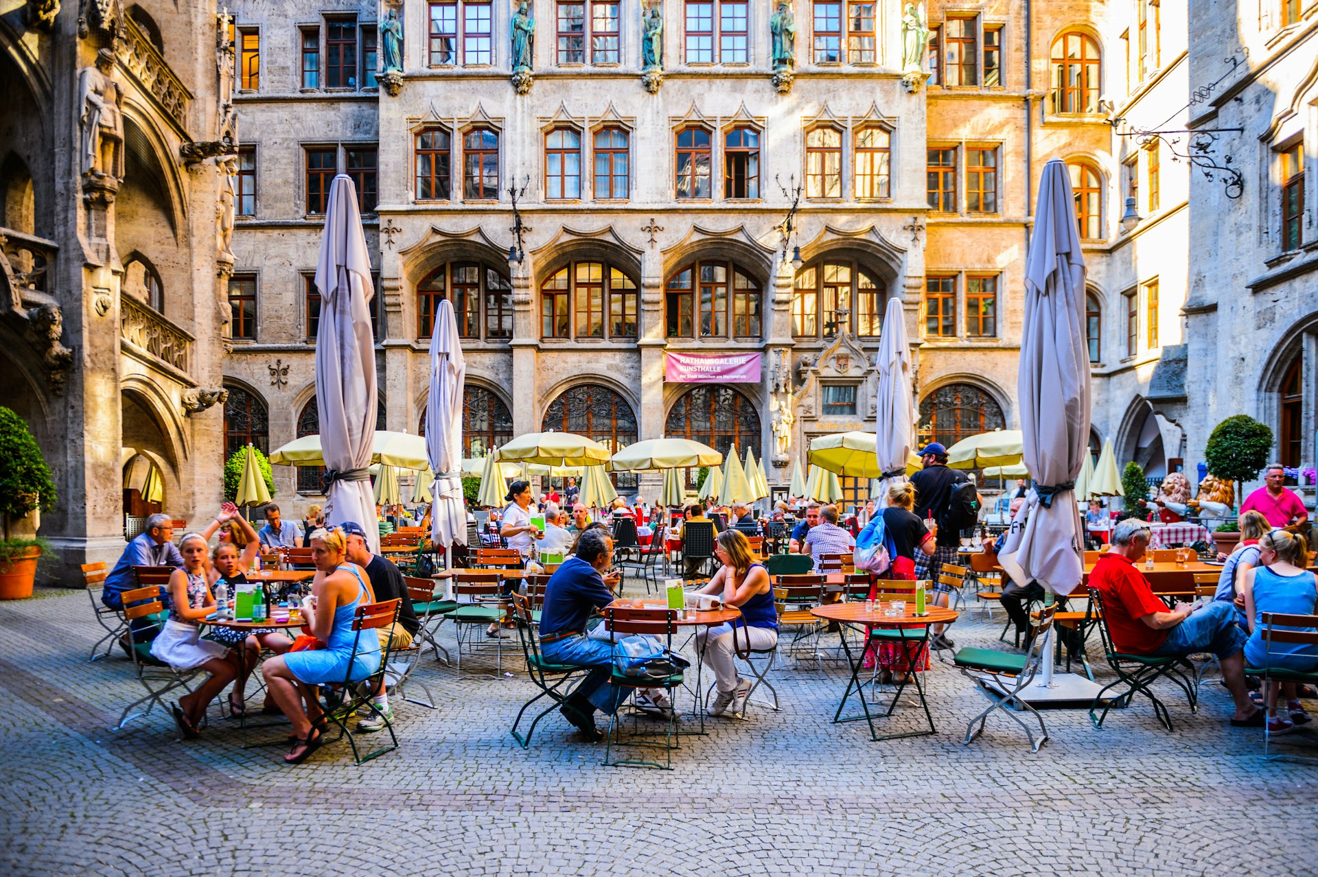 People seated on outdoor tables at Marienplatz in Munich.