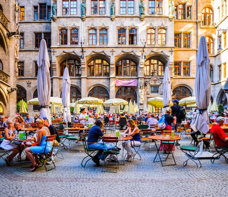 People seated on outdoor tables at Marienplatz in Munich.
