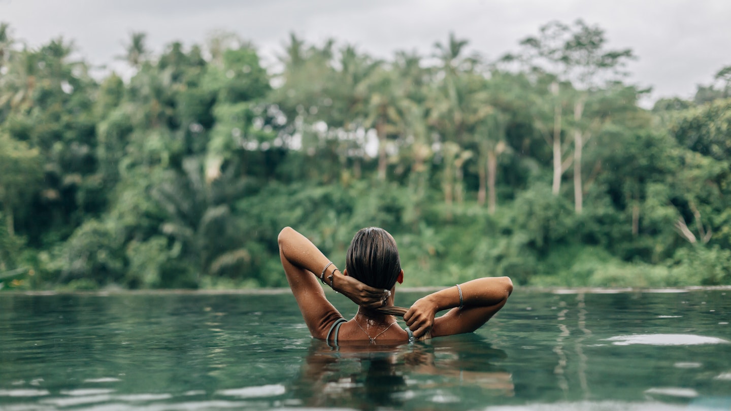 Swimming in infinity pool with a jungle view in Ubud.