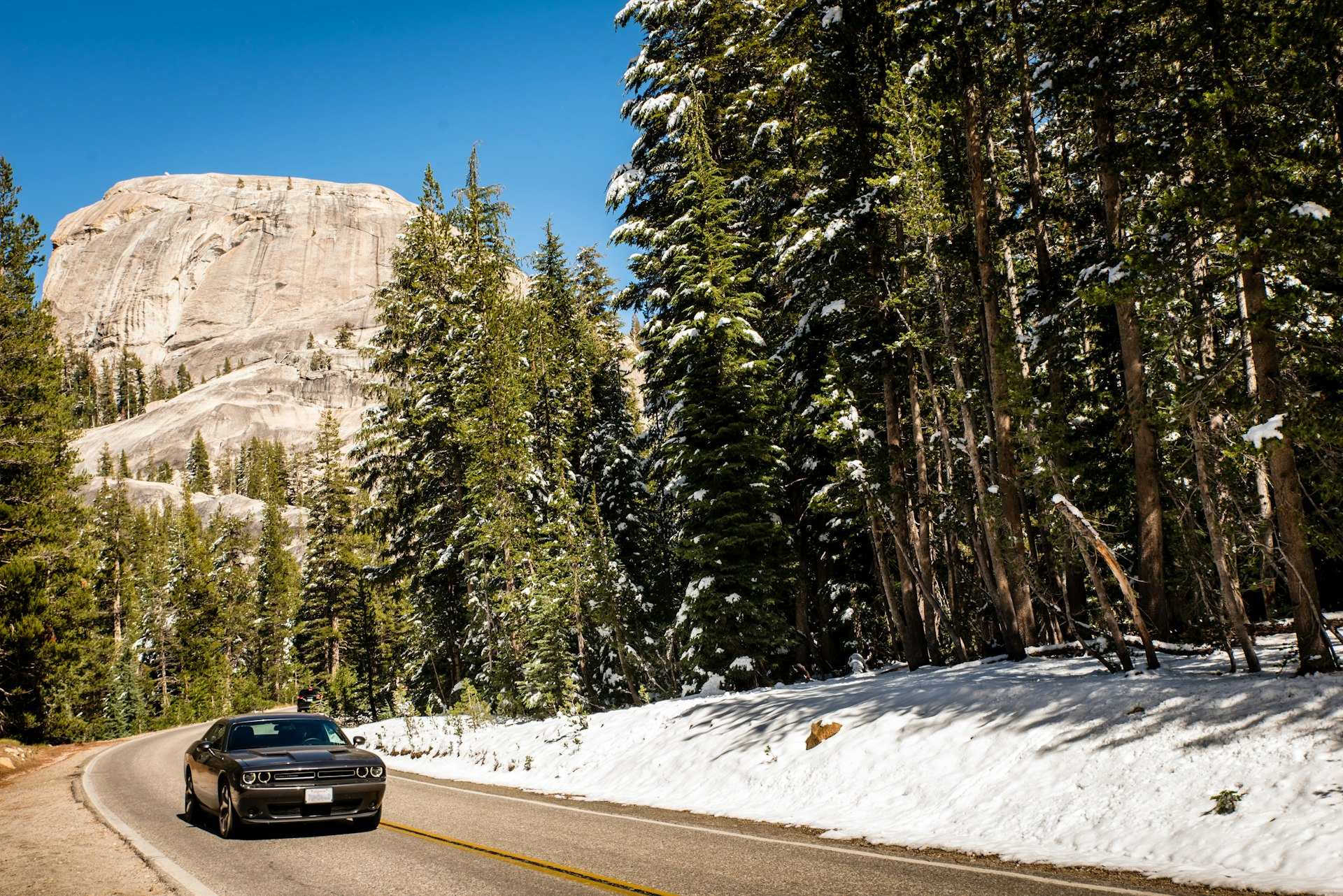 Car and mountain scenery on Tioga Pass road in Yosemite National Park
