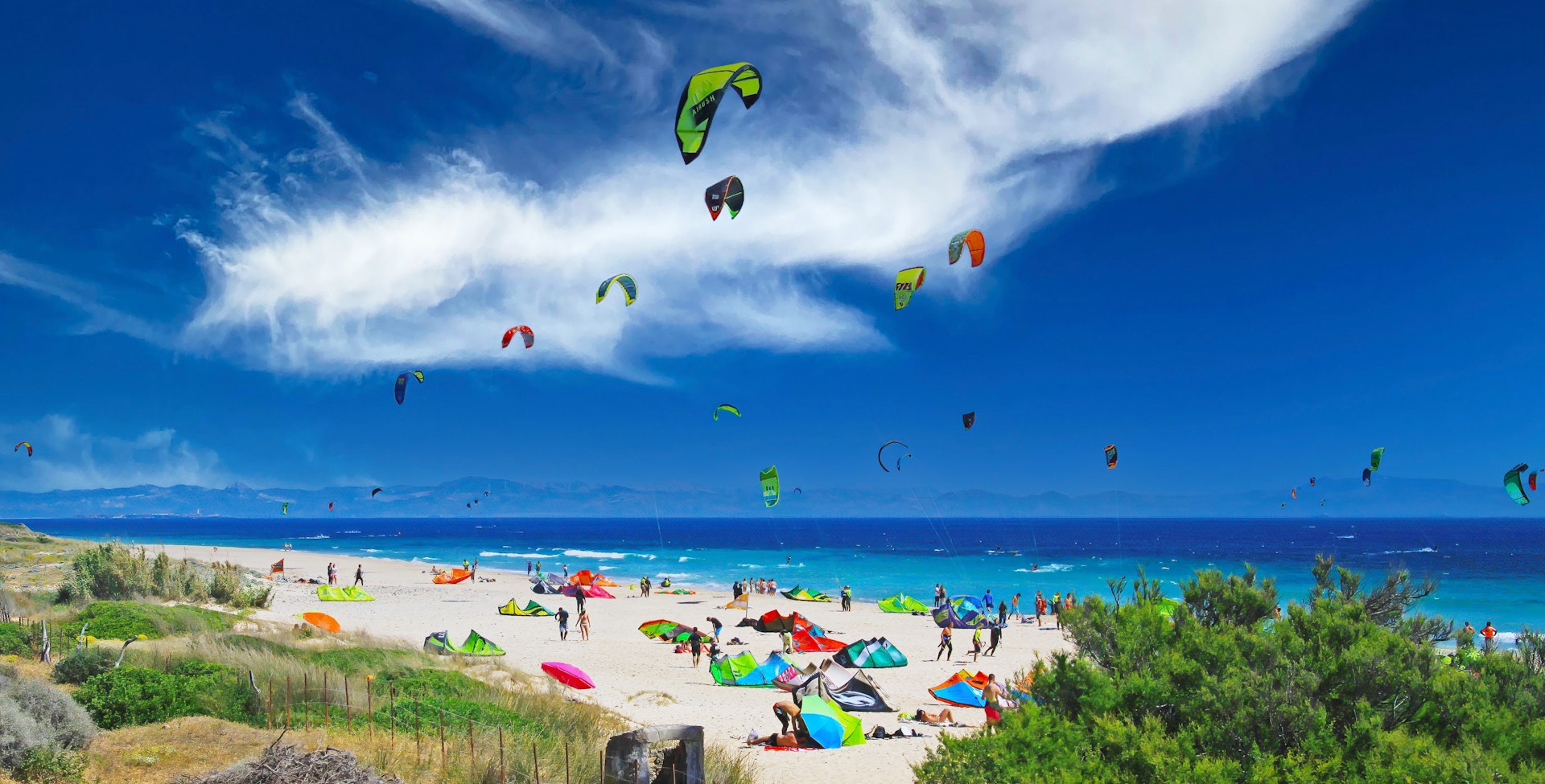 Kitesurfers and sunbathers on the beach at Tarifa, Costa de la Lus, Andalucía, Spain