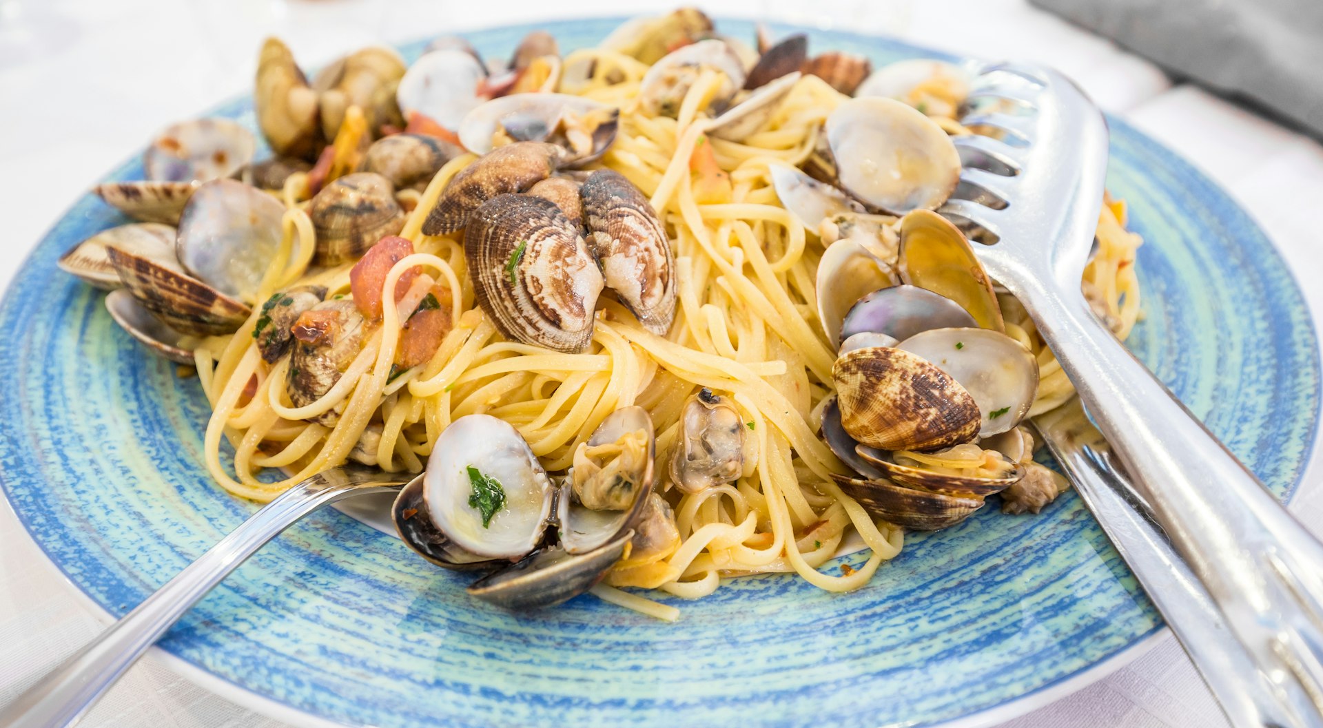 A dish of spaghetti with clams on a white table cloth