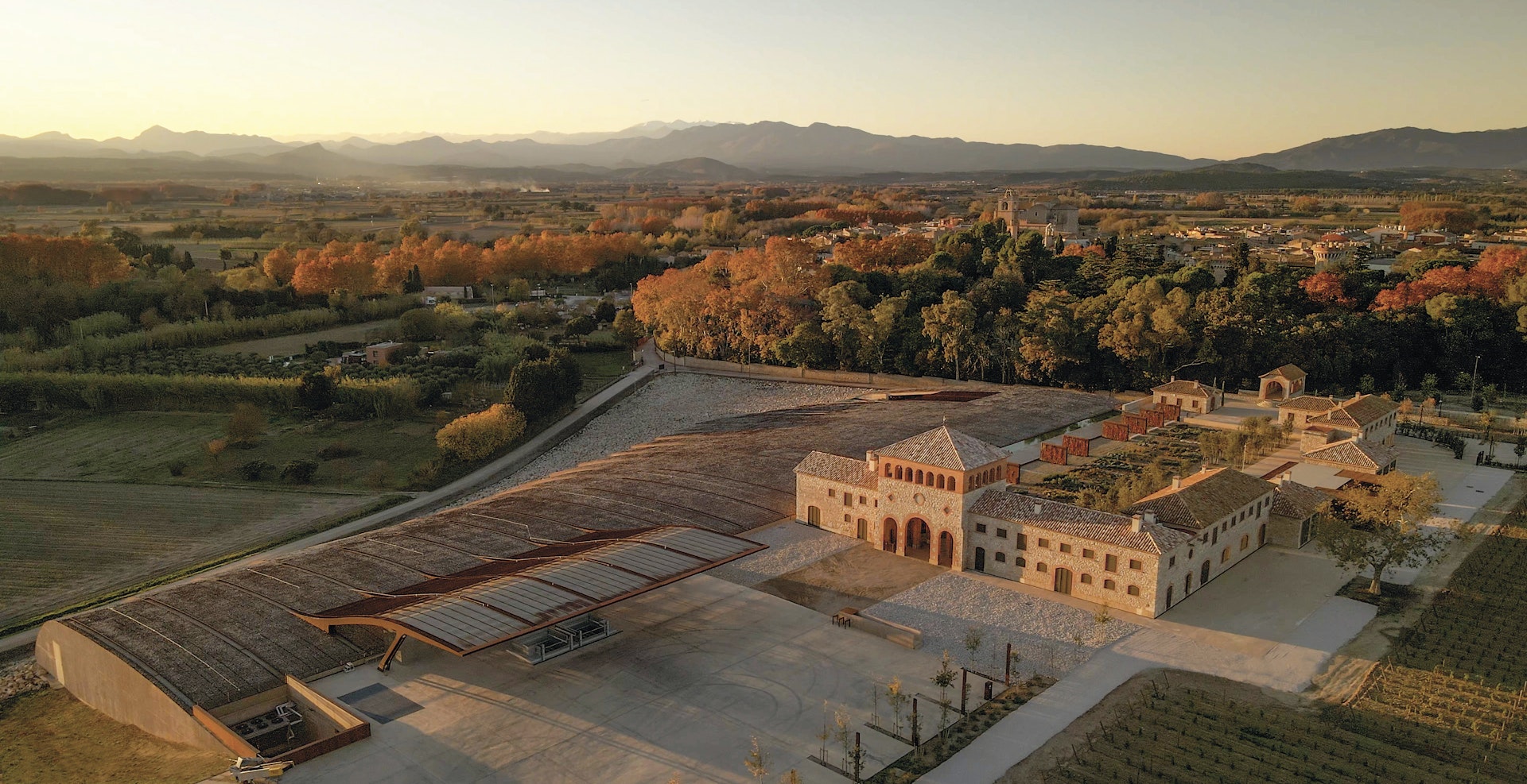 Aerial shot of a wine estate set in a vast stretch of countryside backed by hills