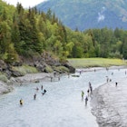 Bird Creek is lined with fisherman hoping to catch silver salmon against the backdrop of the Chugach Mountains on the outskirts of Anchorage, AK.