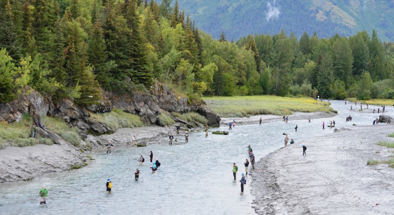Bird Creek is lined with fisherman hoping to catch silver salmon against the backdrop of the Chugach Mountains on the outskirts of Anchorage, AK.