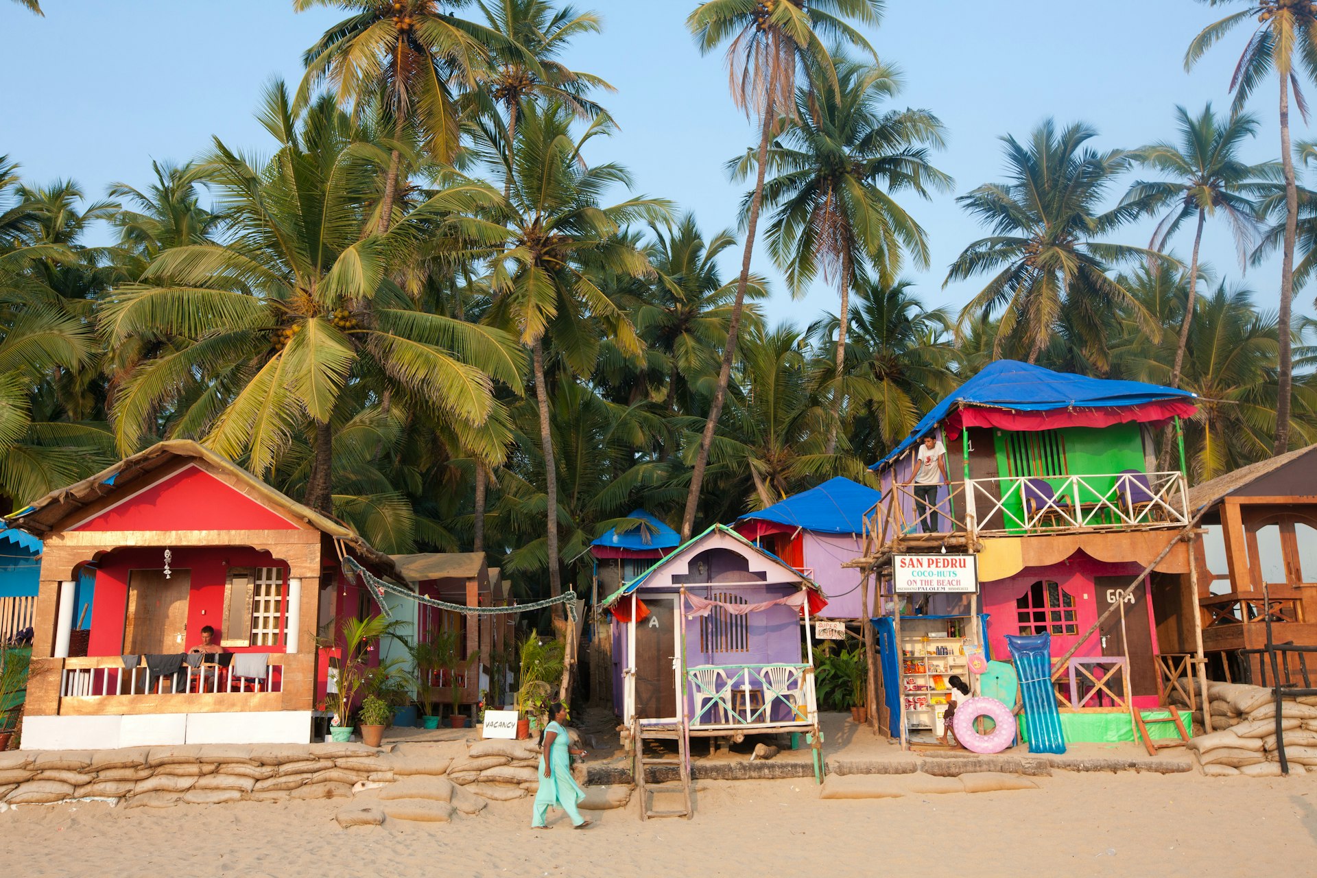 A woman walking along Palolem beach front in Goa, India.