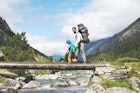 Father and son hiking together in mountains
1135153722
A man and small boy walk across a wooden bridge while hiking in the Pyrenees