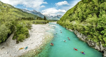 People kayaking on the river Soča in Slovenia.