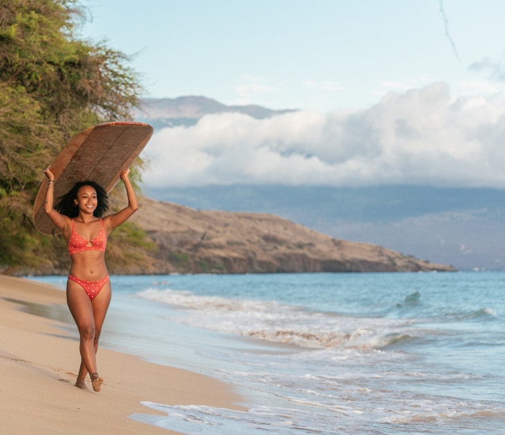 Young woman at the beach carrying her surfboard on her head. Hawaii 2019
1191417513