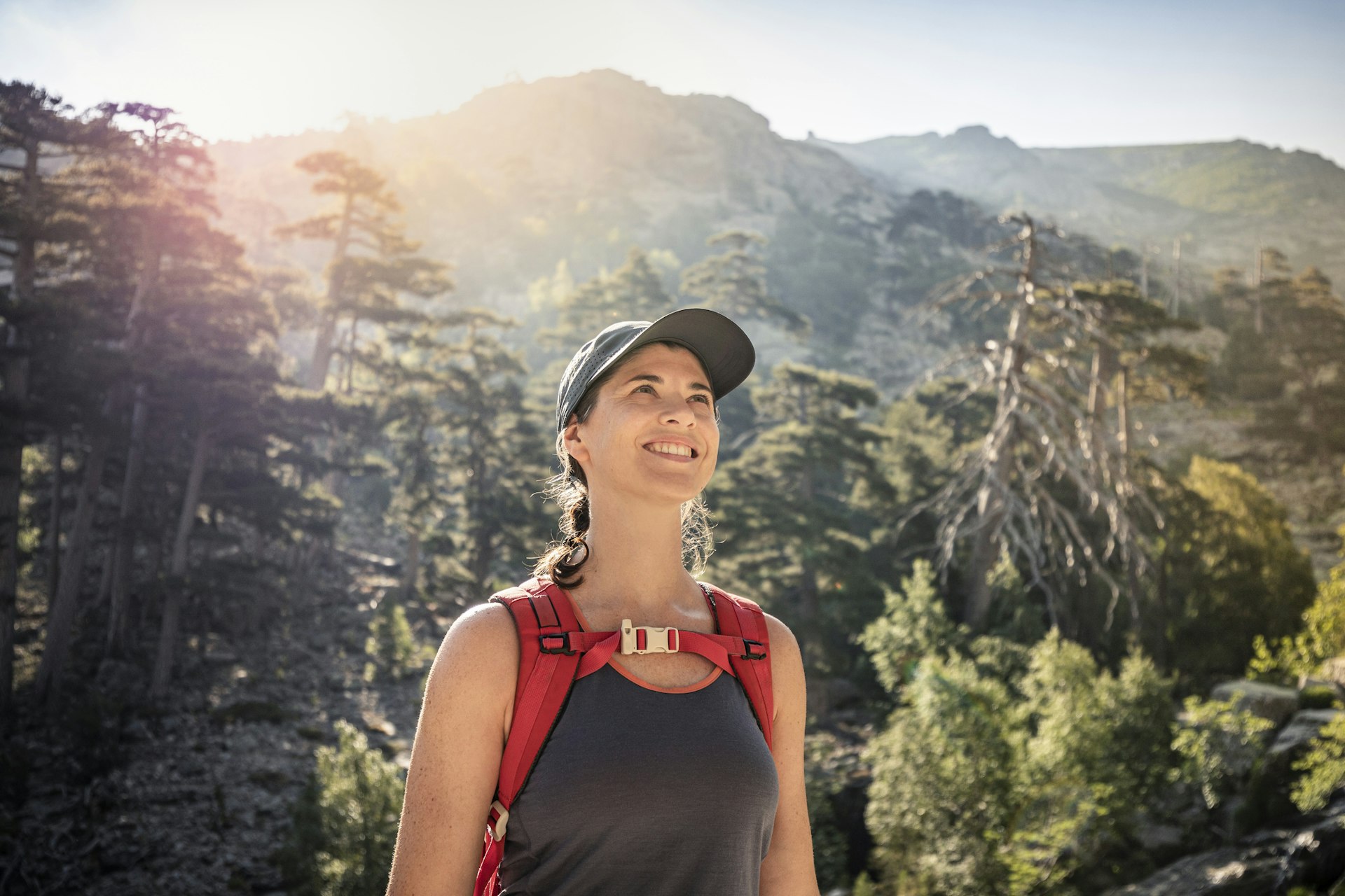 A woman hiker smiling in the sunshine in northern Corsica