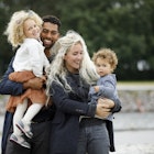 1204595884
A family of four smiling in the sunshine in an urban park