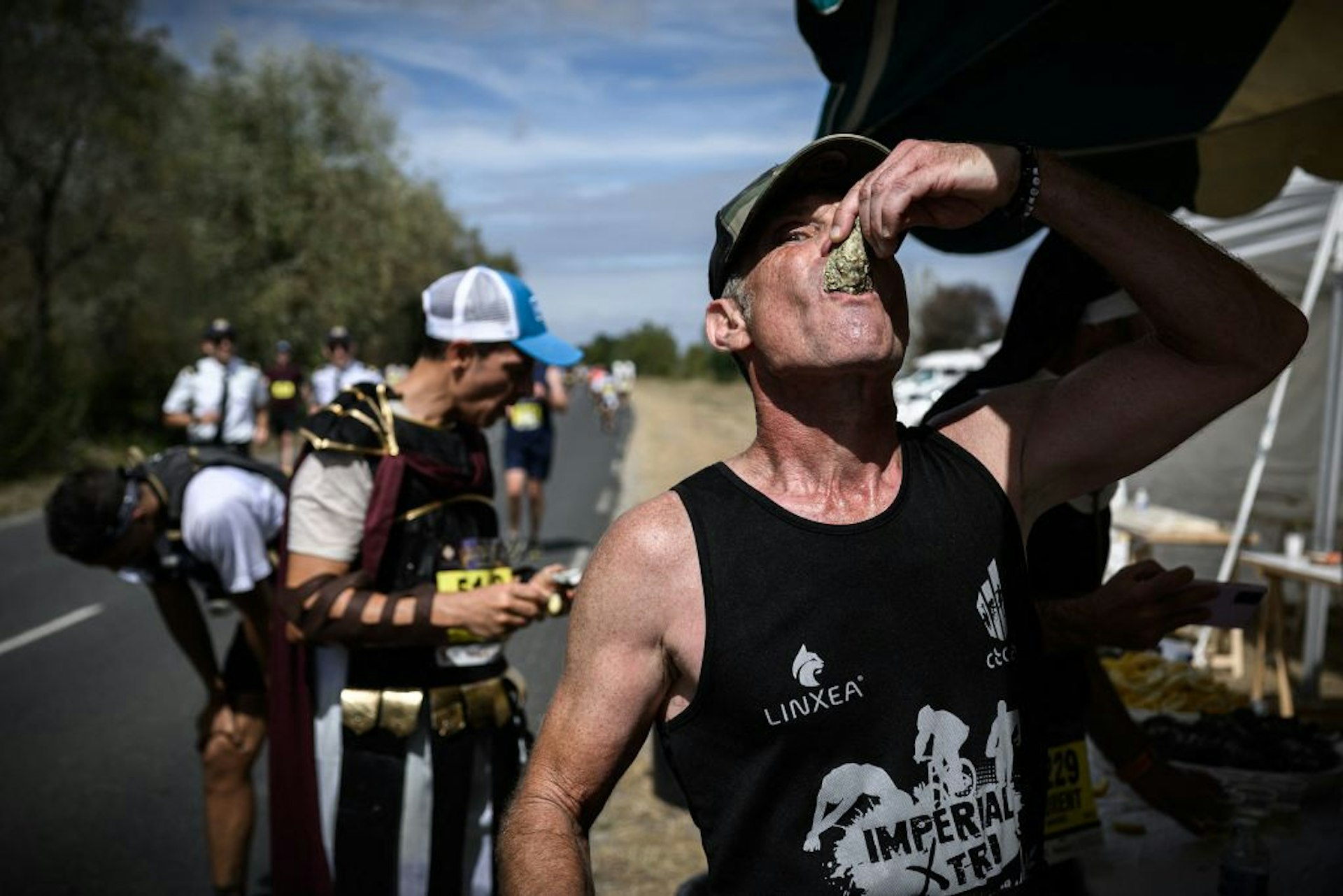 Participants wearing costumes inspired by cinema pop-culture taste oysters as they take part in the Medoc marathon