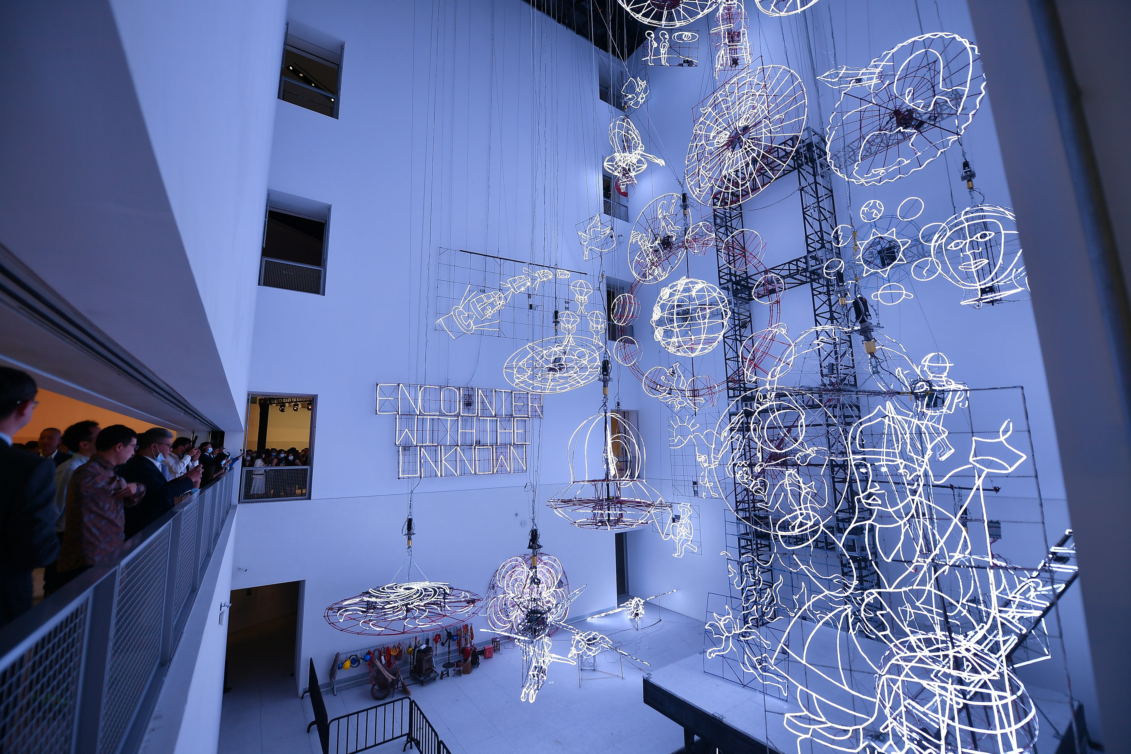 Visitors look at an illuminated art installation in an atrium at the Museum of Art Pudong, Shanghai, China