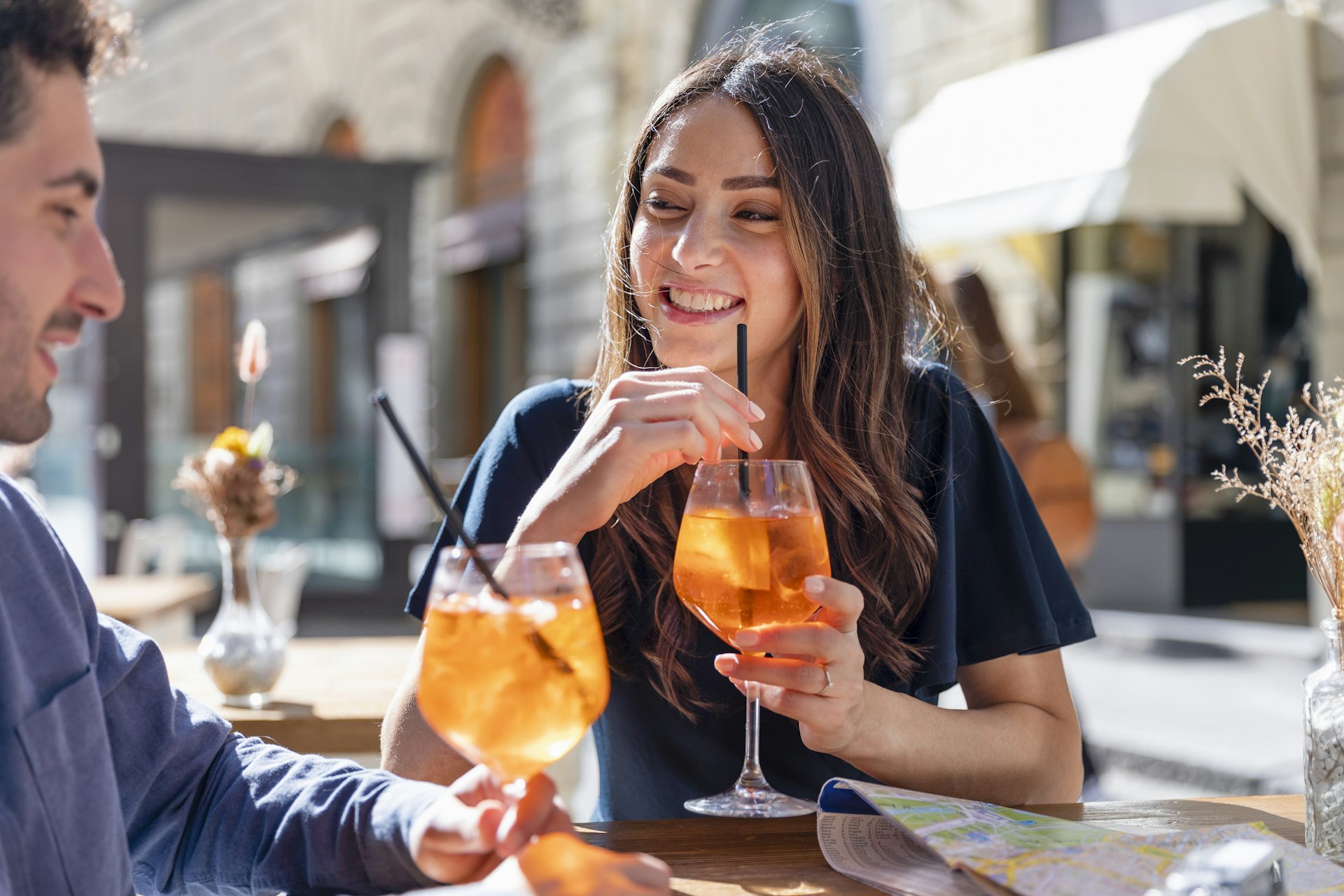 Smiling woman and man drinking cocktails outdoors in Florence