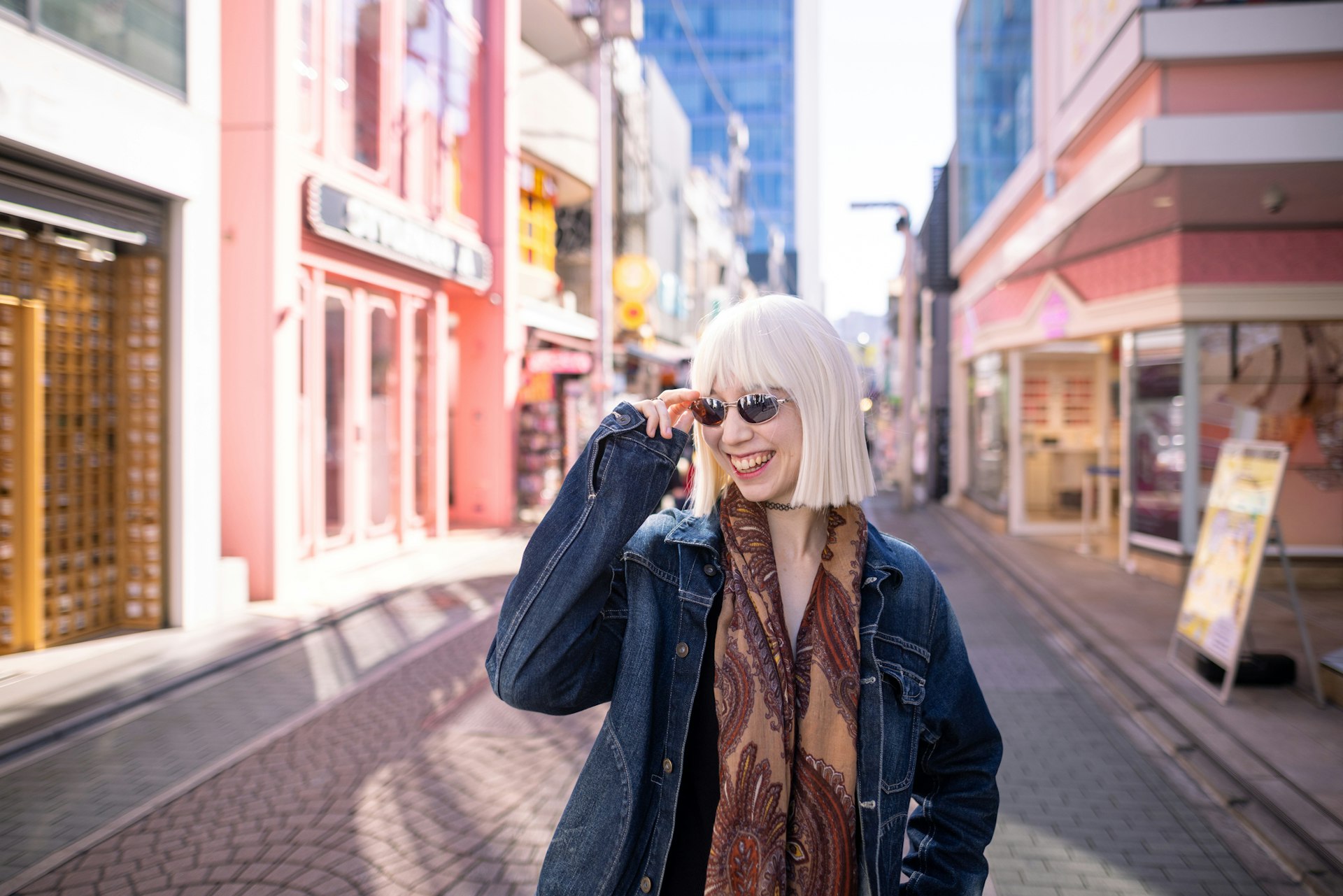 Young multiracial woman with platinum blonde wig visiting Harajuku and take photos/videos for blogging/vlogging.