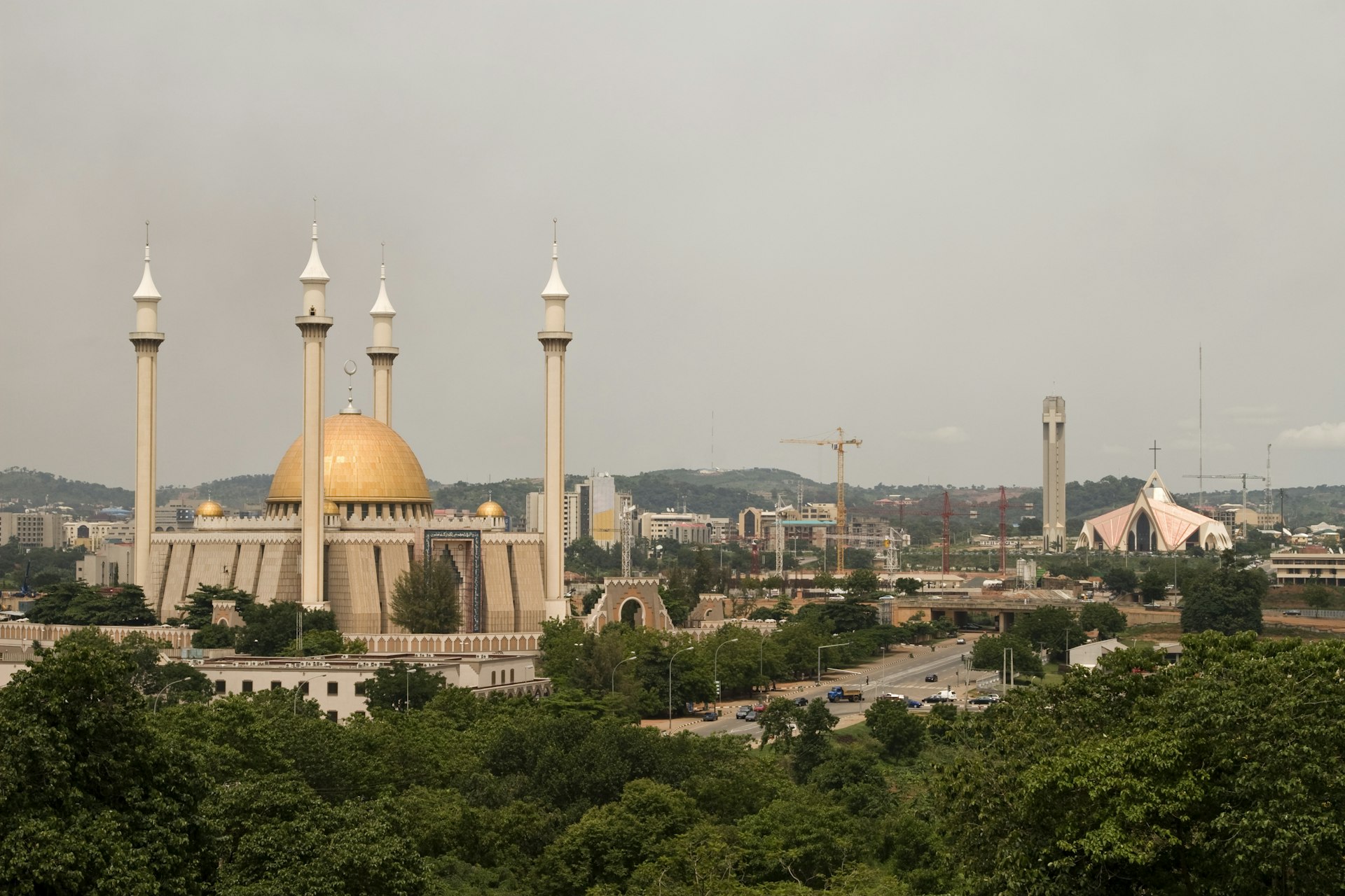 A build-up city skyline with a mosque to the left and a church to the right 