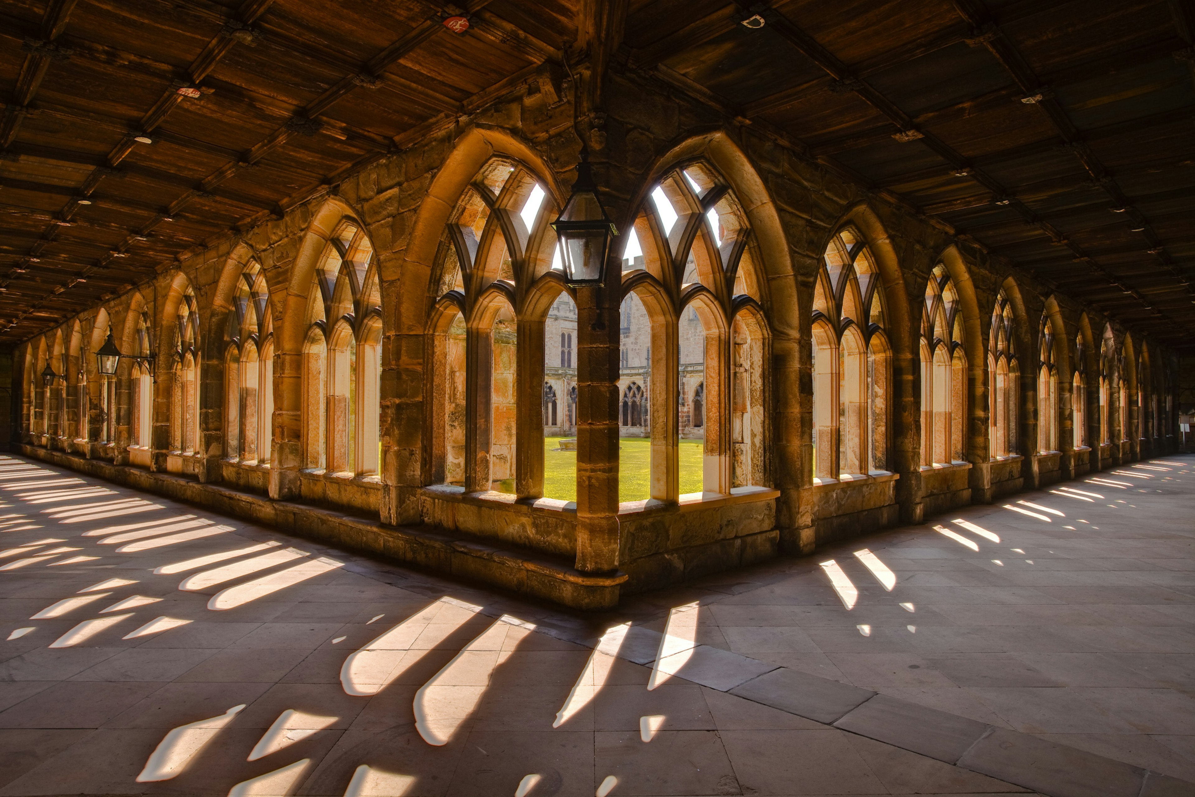 Cloisters in a cathedral form arches of light on the flagstone floor