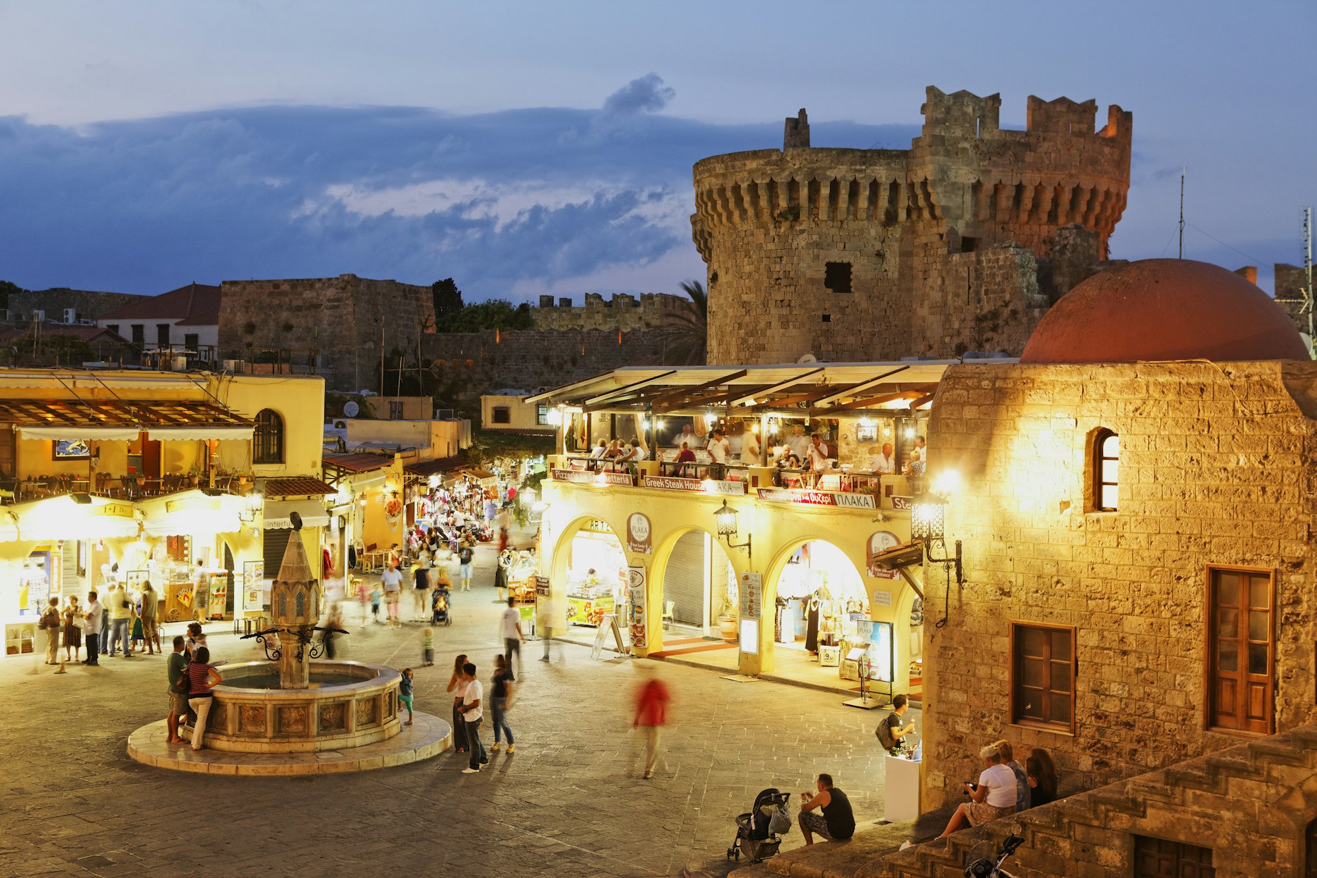 Tourists at night in the historic town center of Rhodes, Dodecanese, Greece
