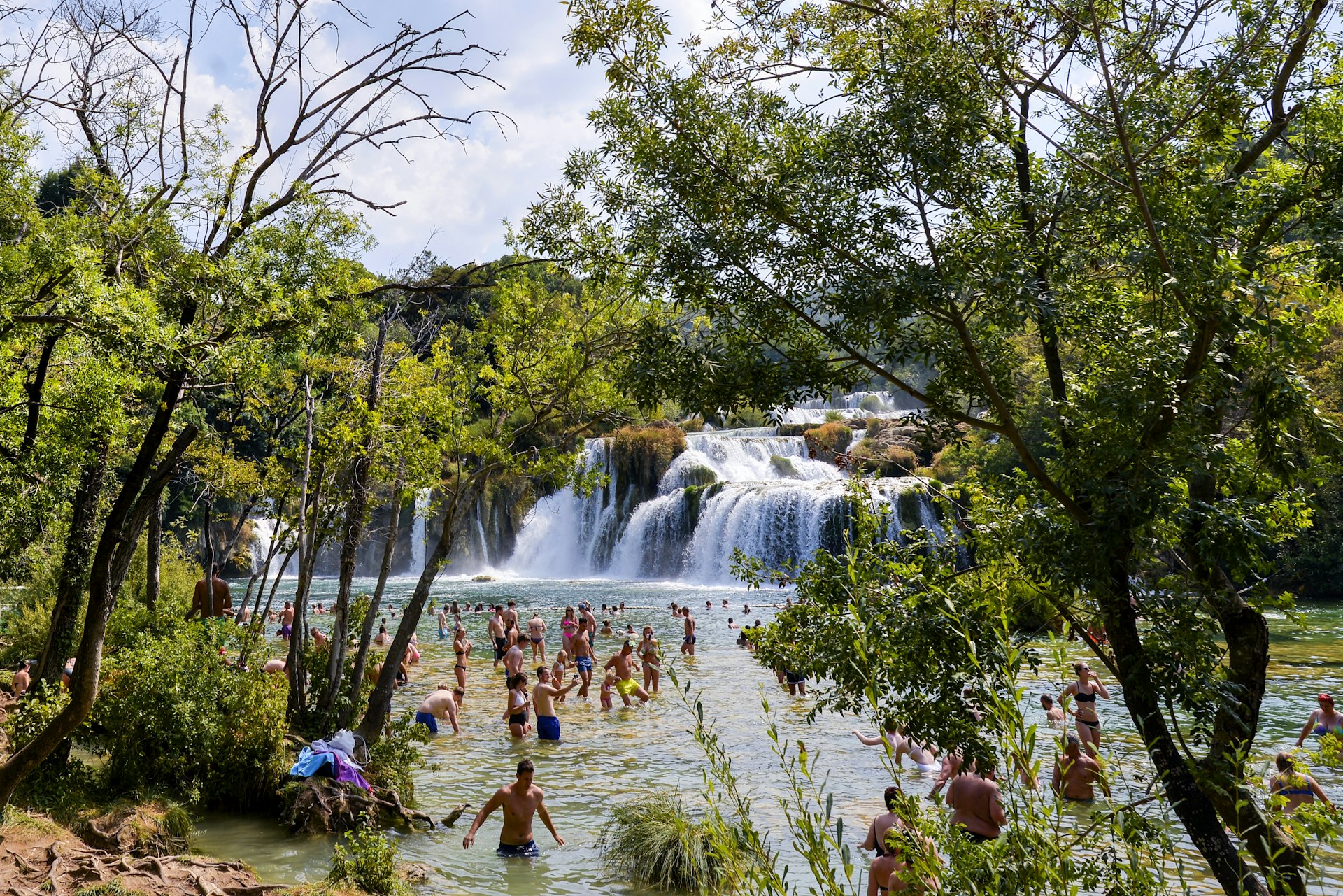 Crowds wade into the pool by waterfalls in Krka National Park, Croatia, Europe