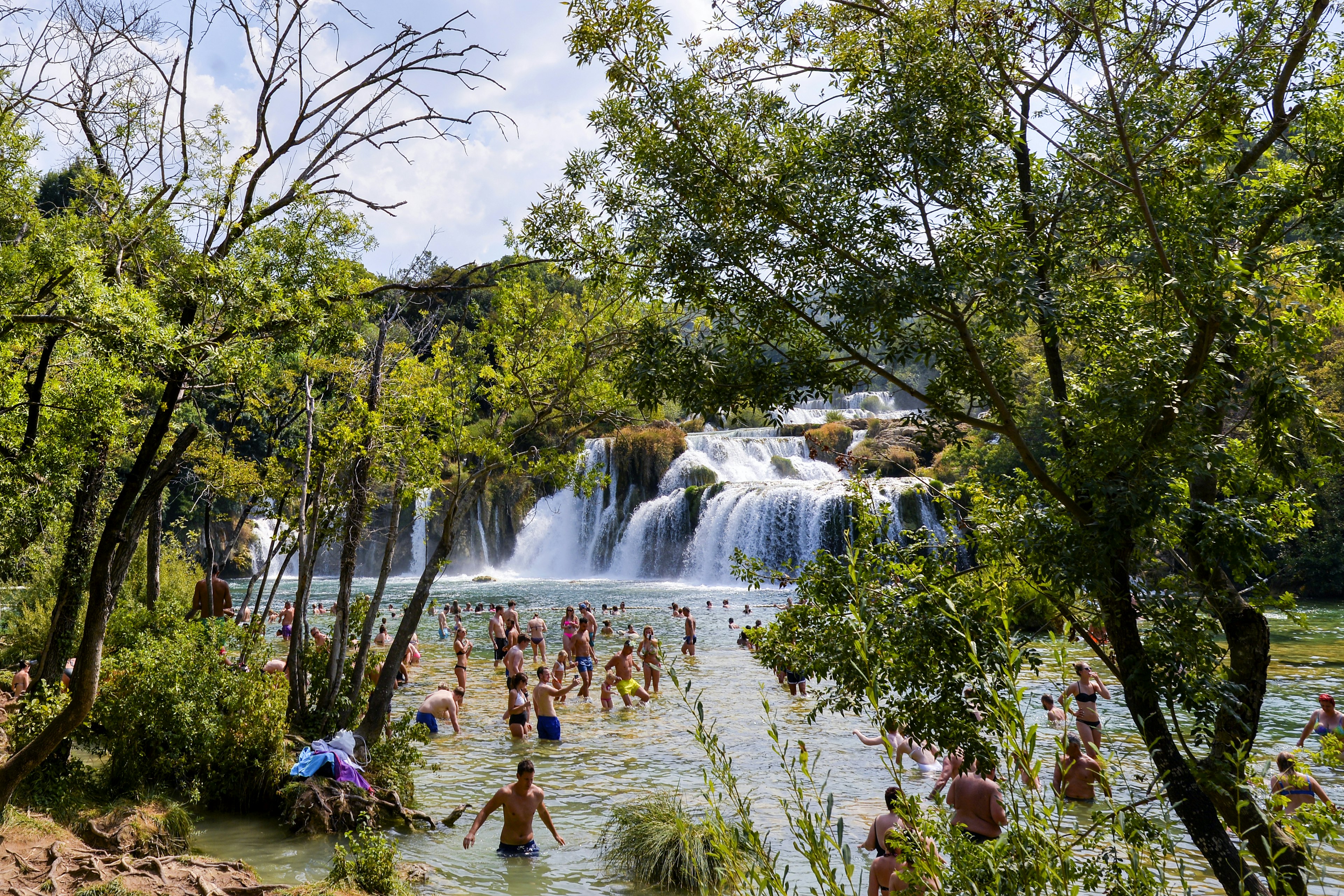 Crowds wade into the pool by waterfalls in Krka National Park, Croatia, Europe