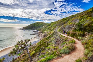 People walking the Coast Track in Noosa National Park.
