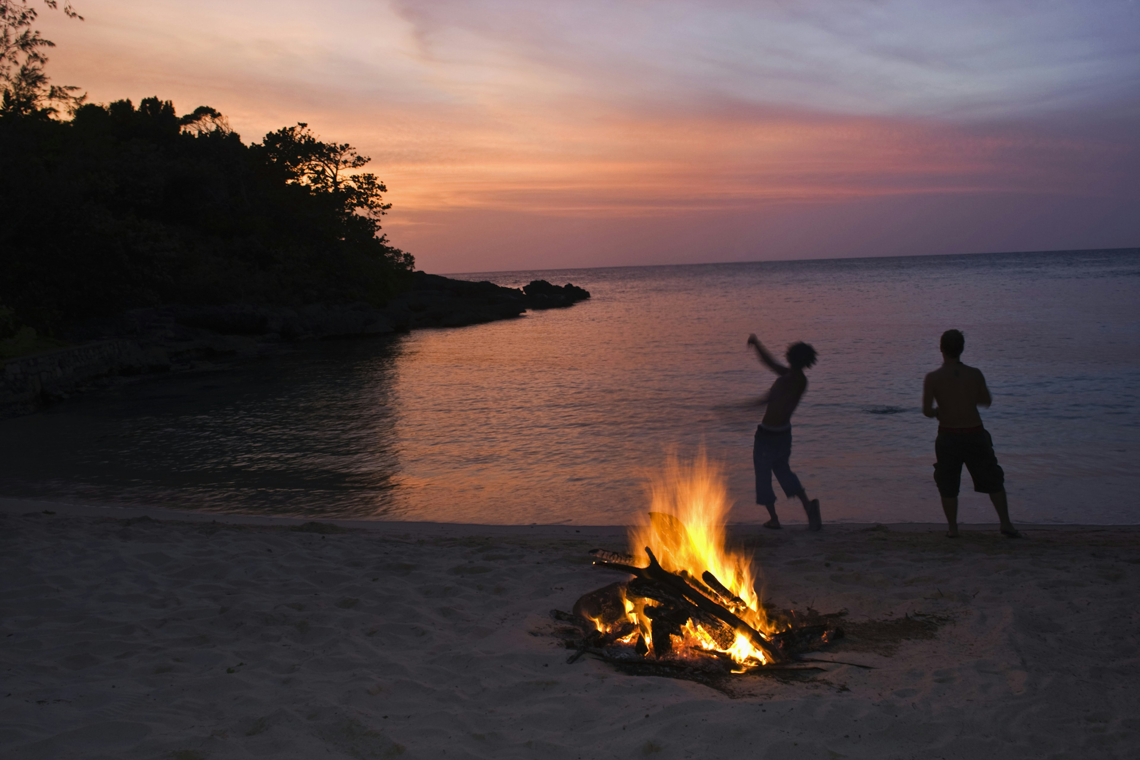 Beach bonfire and silhouetted people