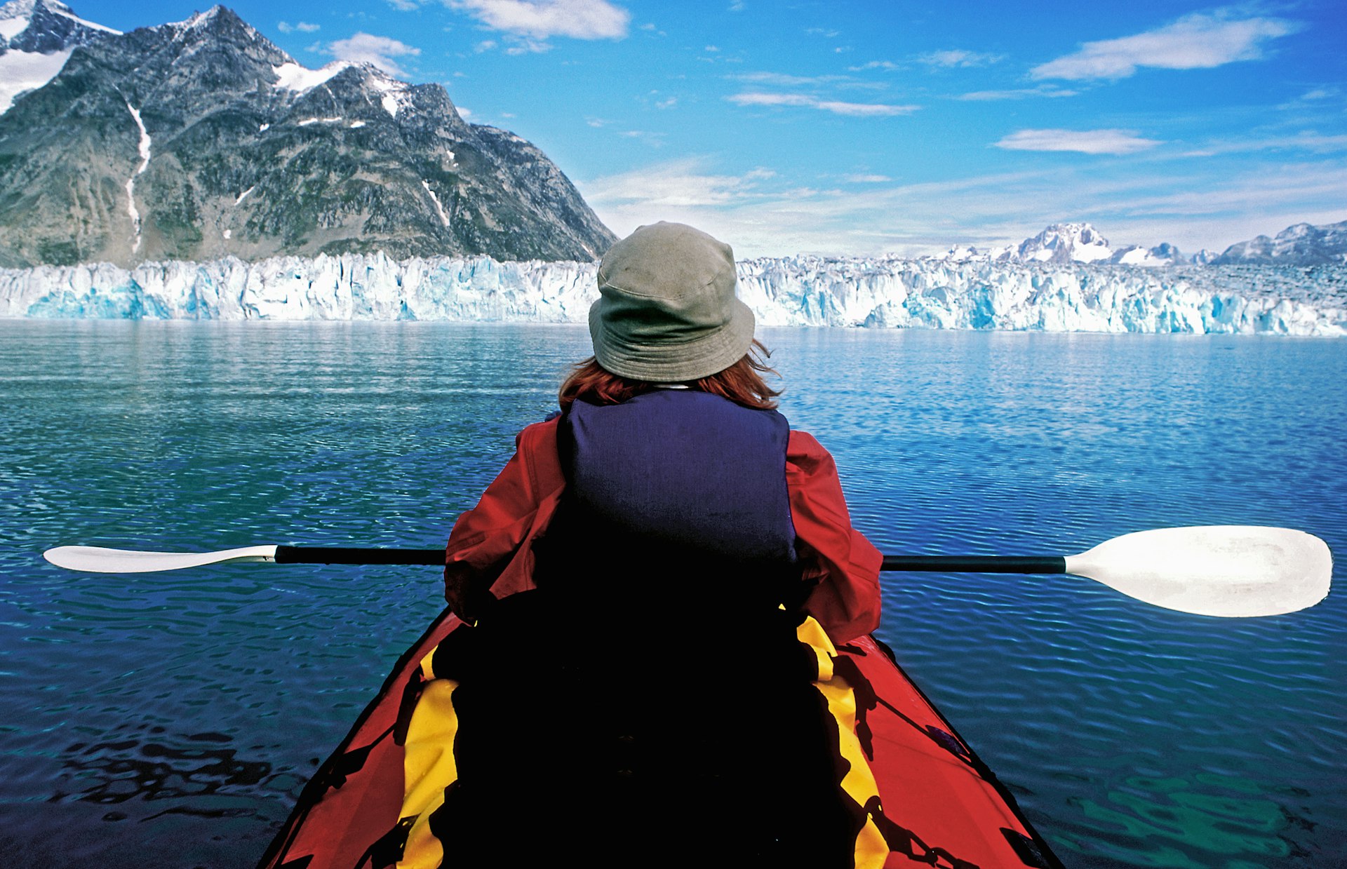 Rear view of a woman kayaking in glacial lake, Greenland