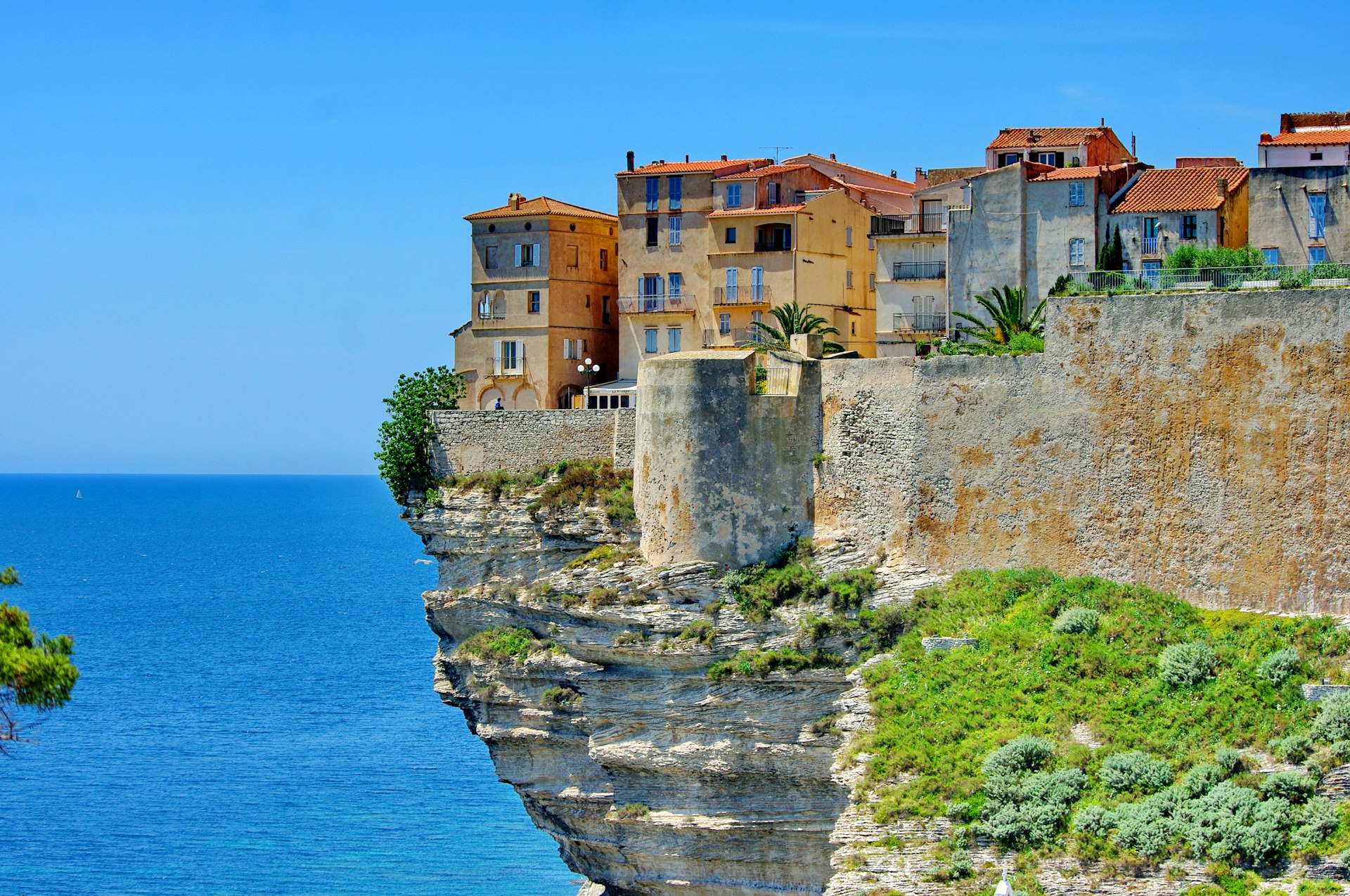 Houses clustered together on the edge of a cliff in Bonifacio, Corsica