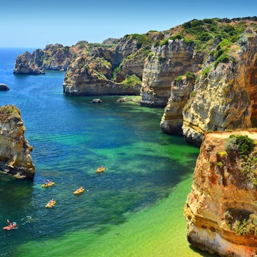 Kayaks navigate through the crystal waters of Praia Dona Ana, Lagos.