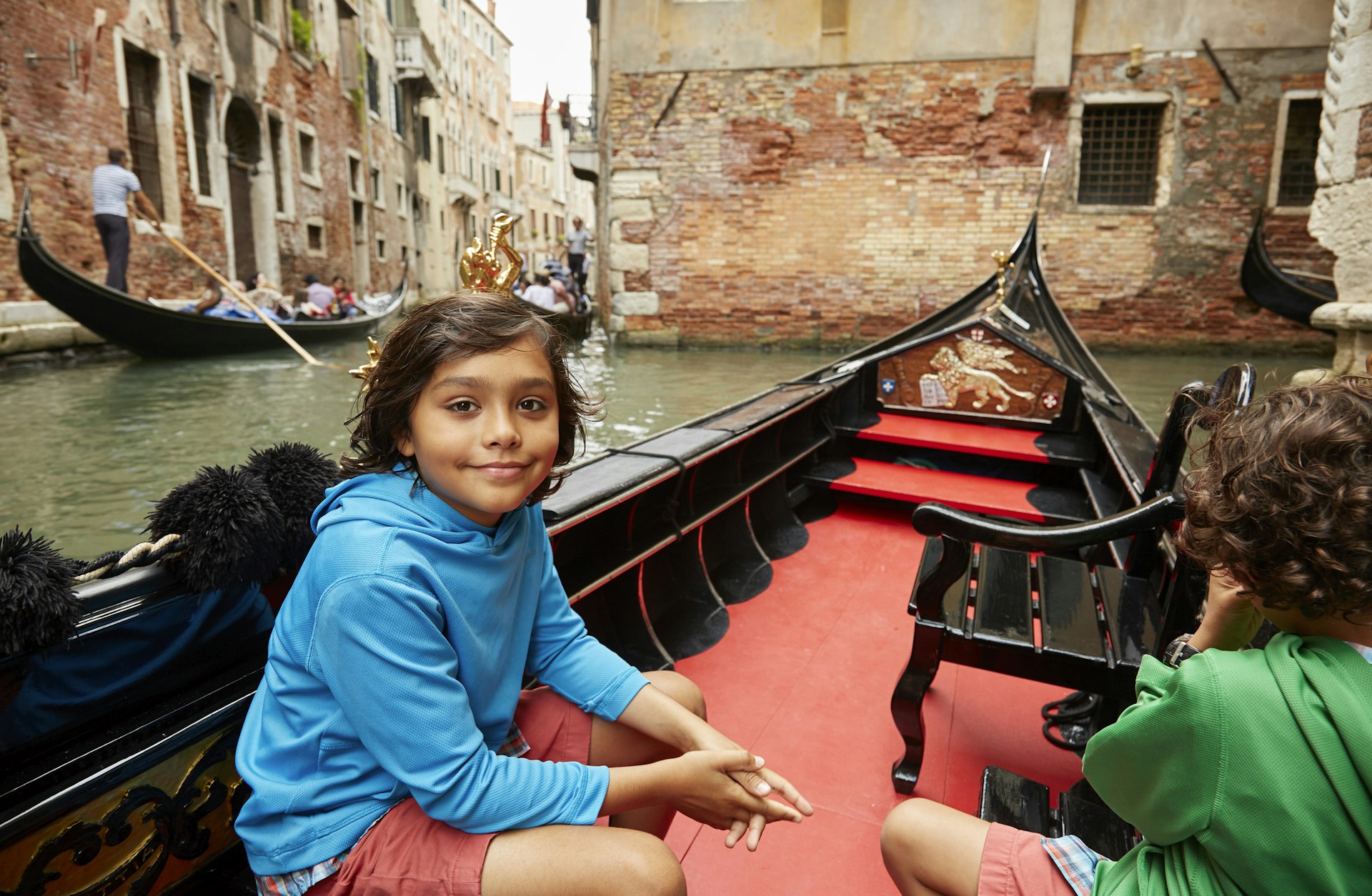 Boy sitting in a gondola on the Venice canal.