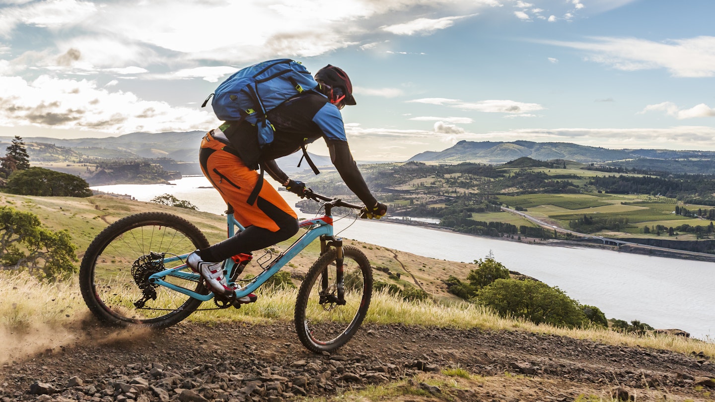 Mountain biker riding on a trail along the Columbia River in Hood River, Oregon.
