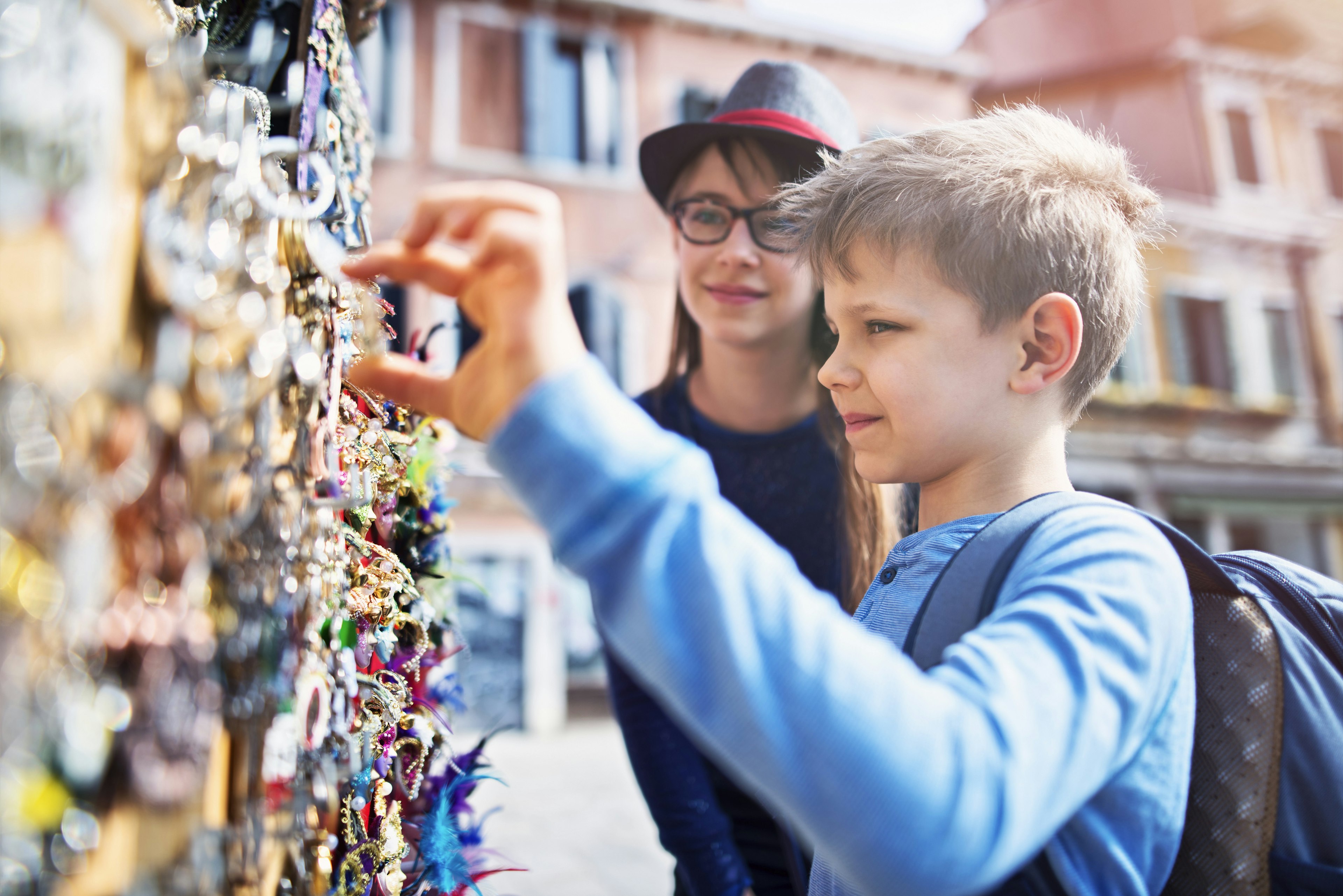 Kids browsing souvenirs at an outdoor stall in Venice