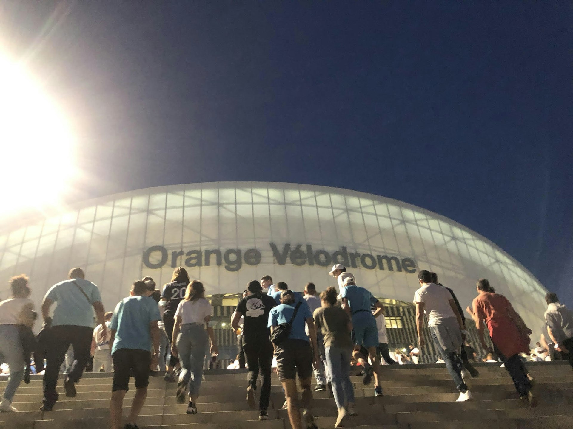 Fans walking up the stairs to the Stade Vélodrome at night 