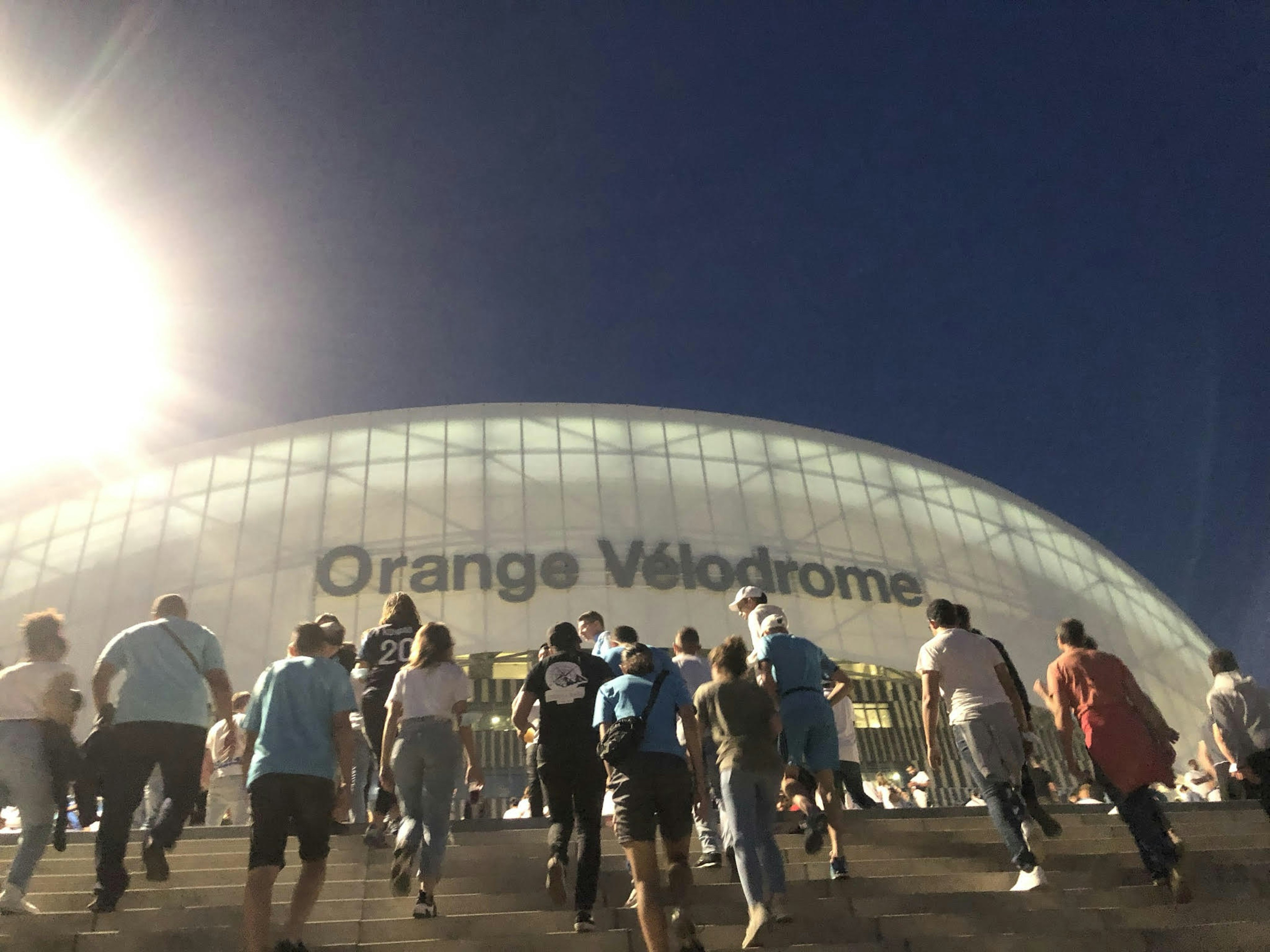 Fans walking up the stairs to the Stade Vélodrome at night