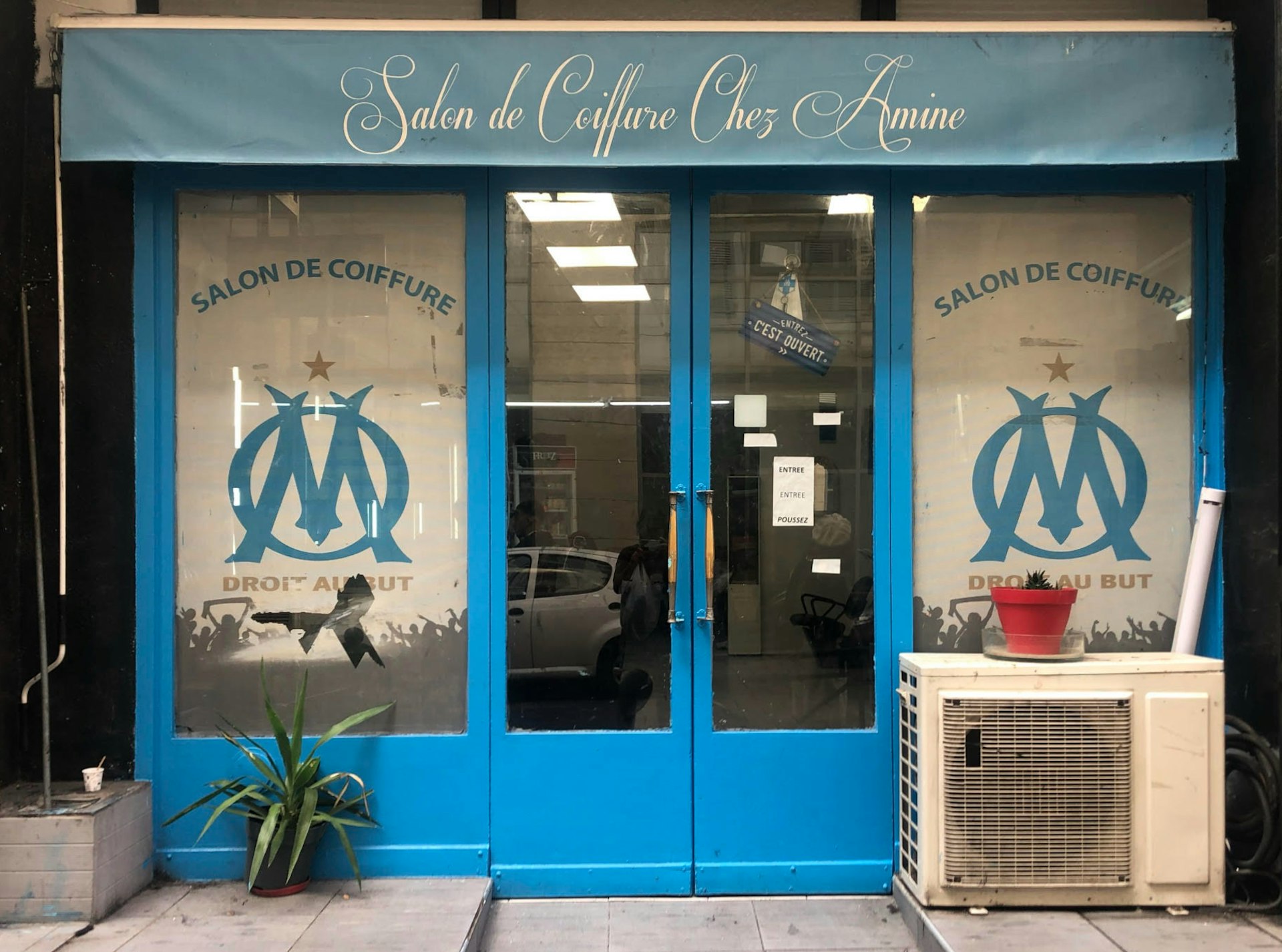A storefront in Marseille with OM signage in the windows 