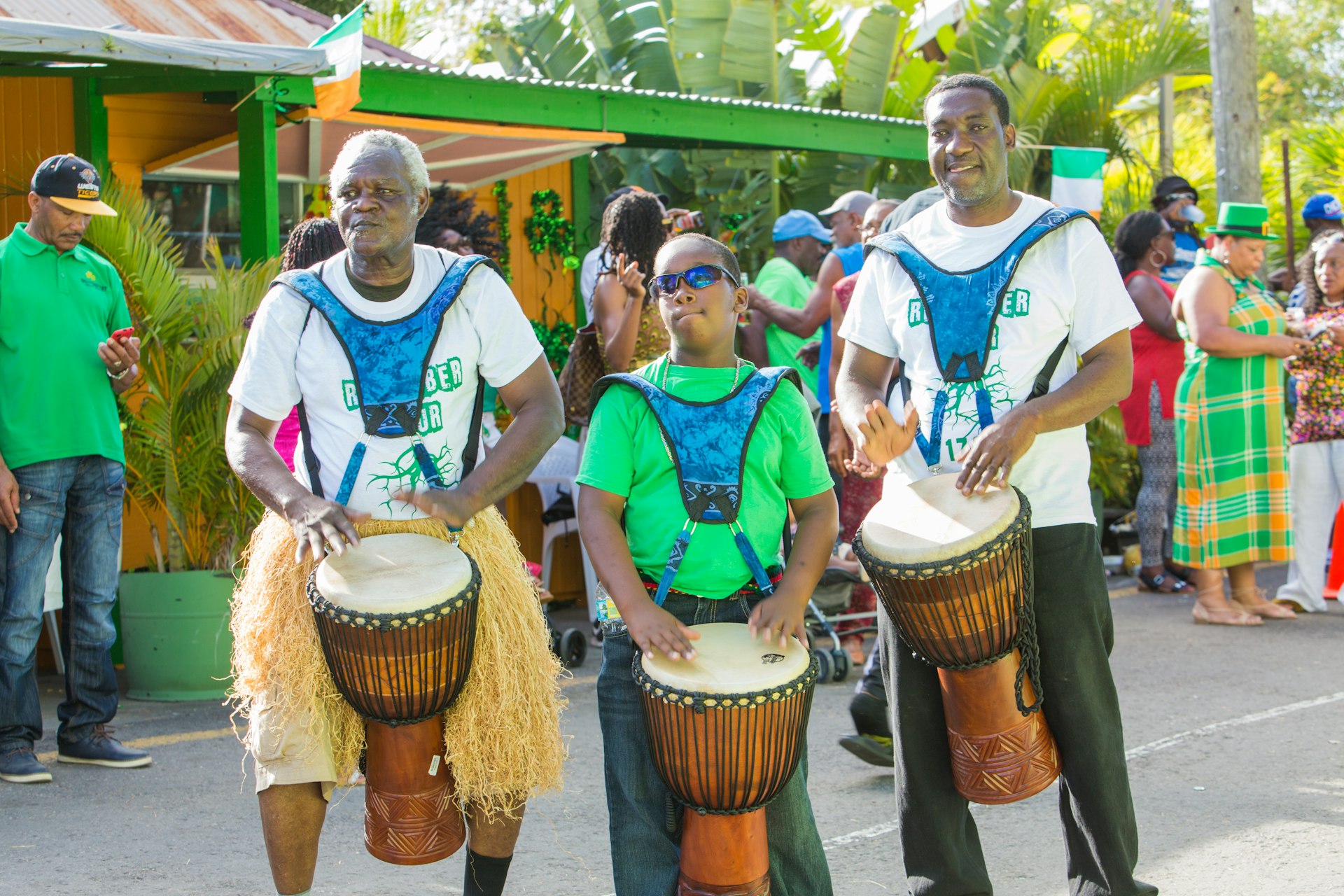 A trio of men tap on drums with their hands during Montserrat's St. Patrick's celebrations