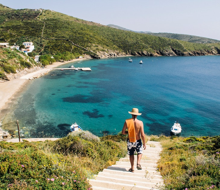 Rear view of a man walking down to a beach on Fourni Island, Greece.