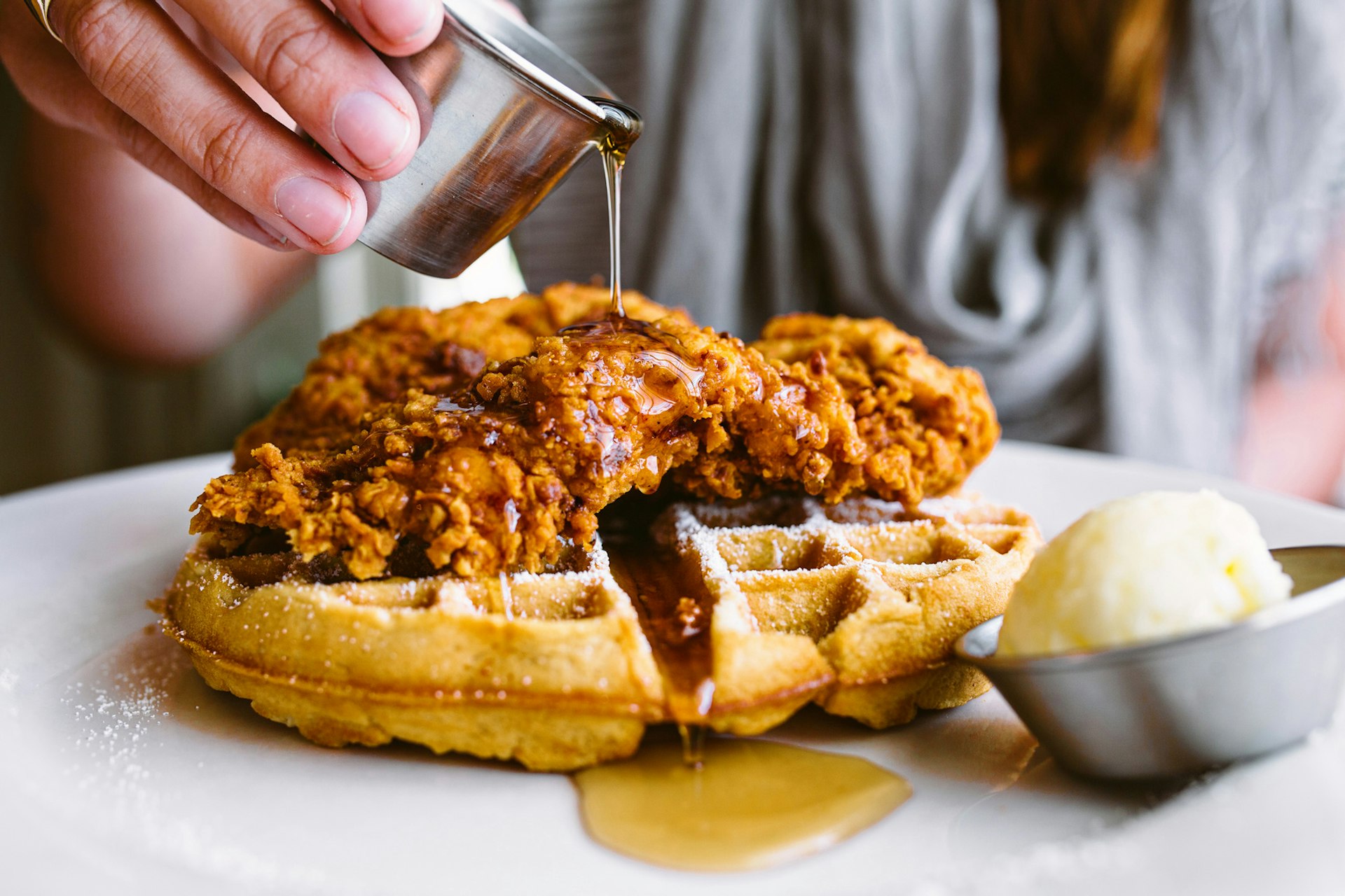 Syrup being poured over chicken and waffles in Atlanta.